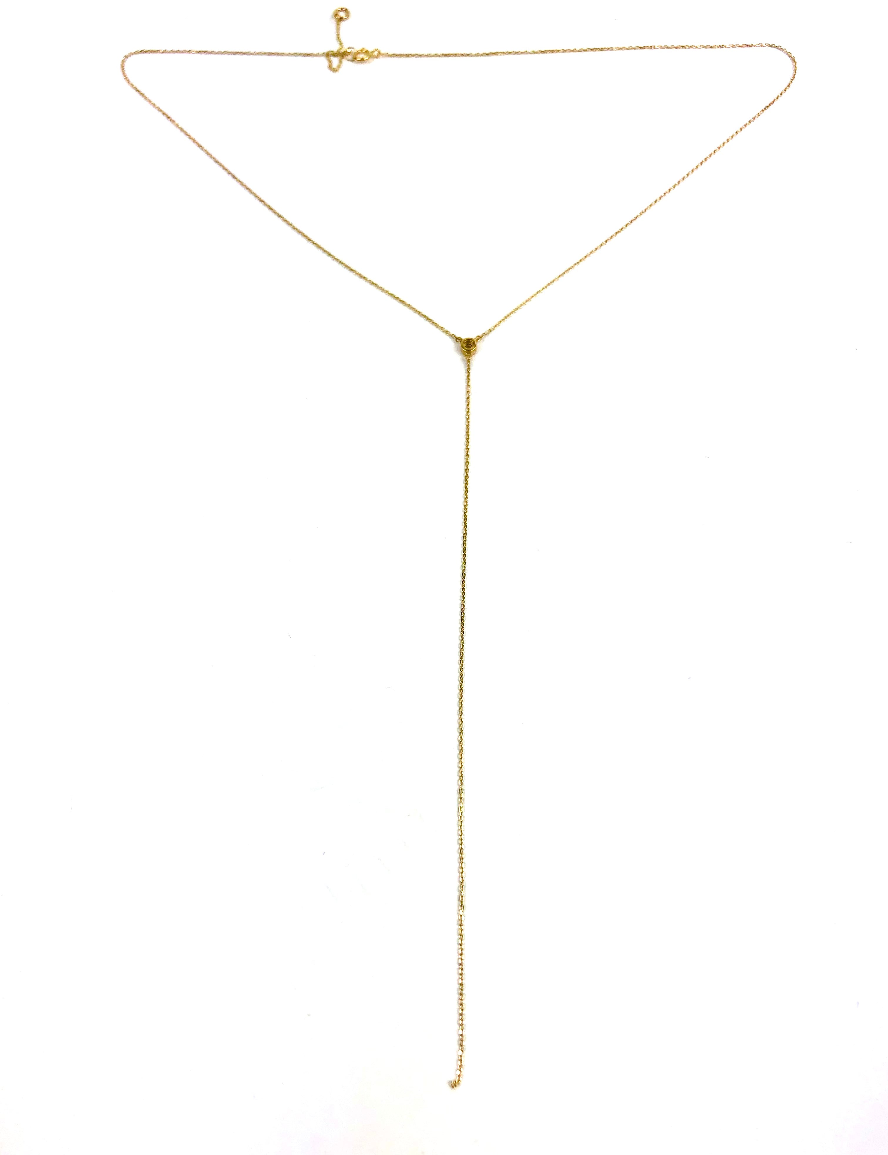 Gold lariat necklace on a white background