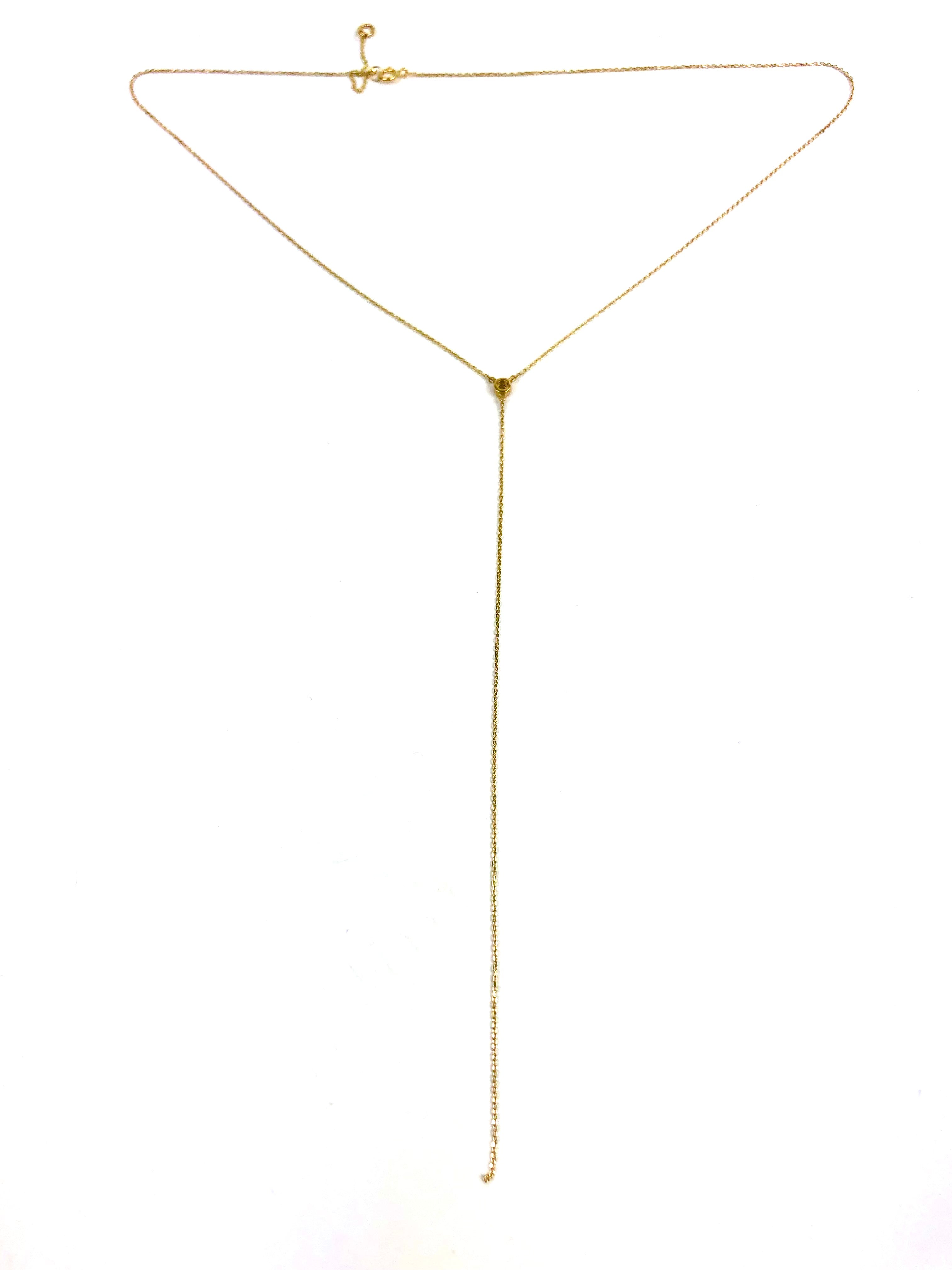 Gold lariat necklace on a white background