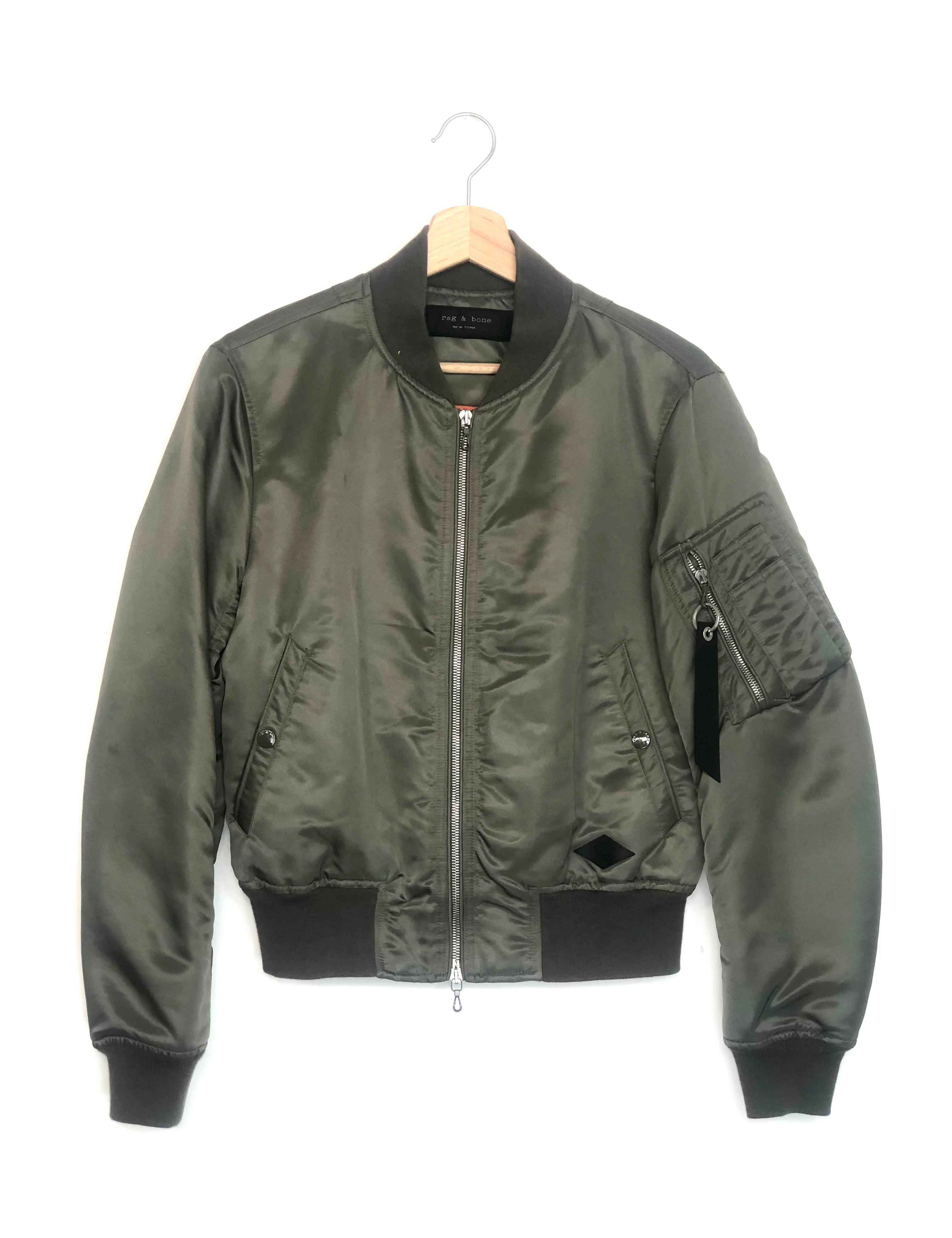 Green bomber jacket on a hanger against a white background