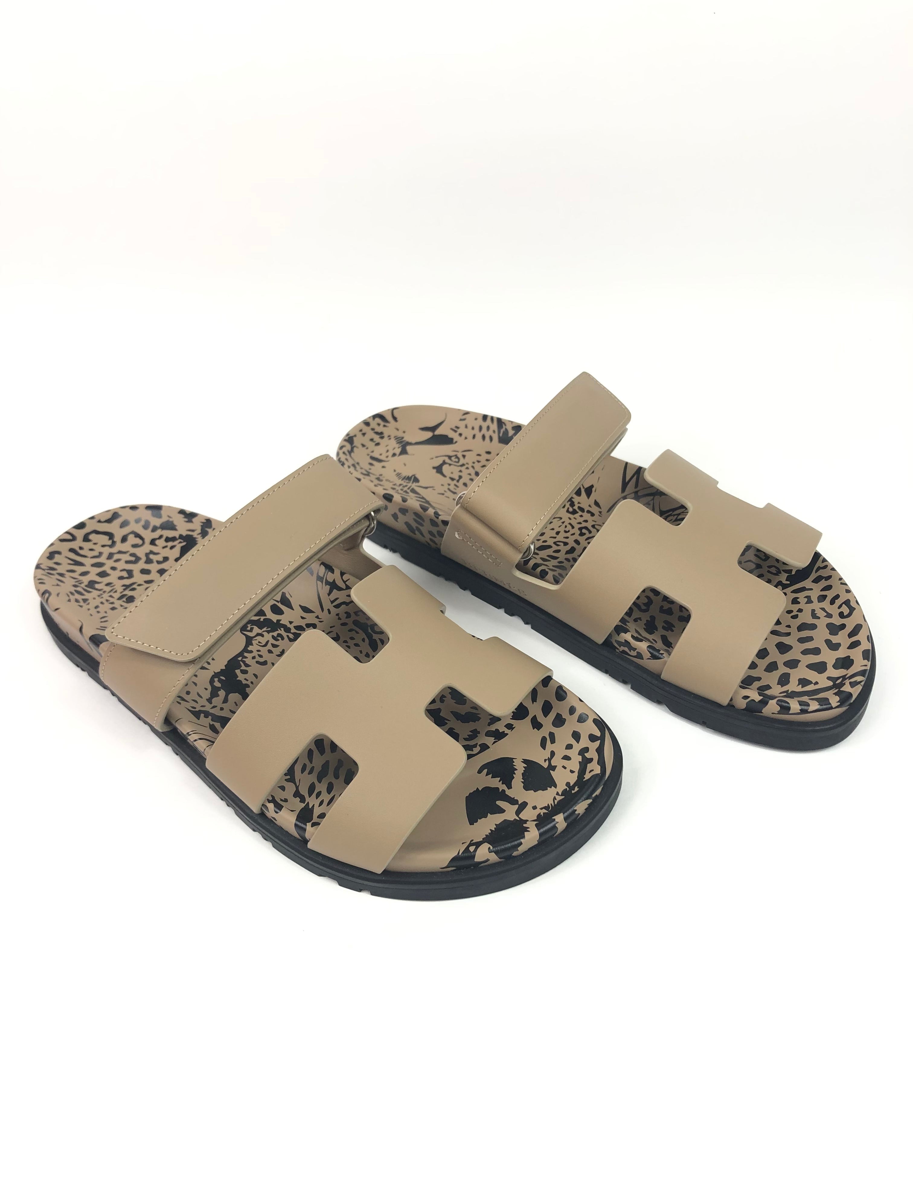 Pair of beige slides with leopard print soles on a white background