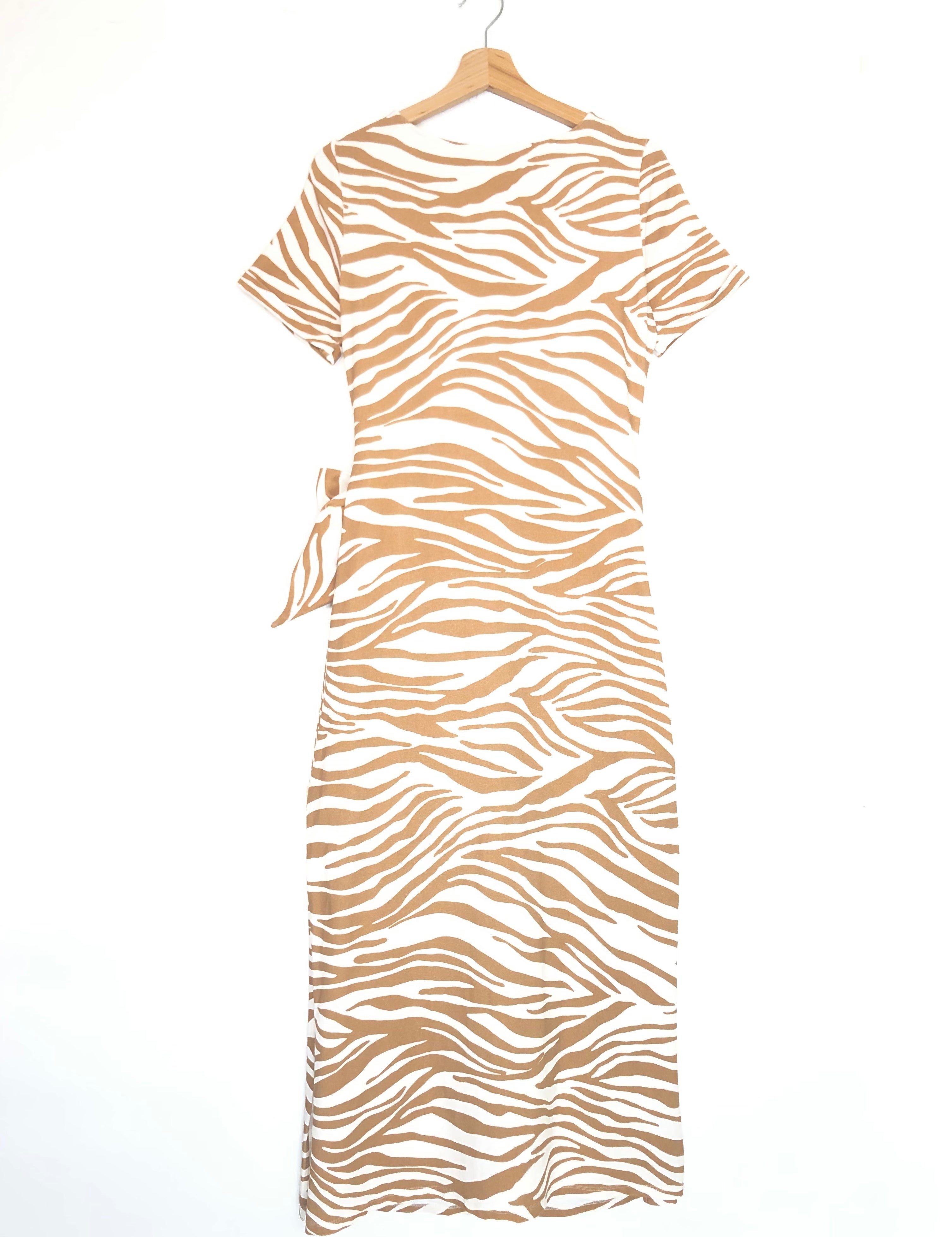Beige and white zebra pattern dress on a hanger against a white background