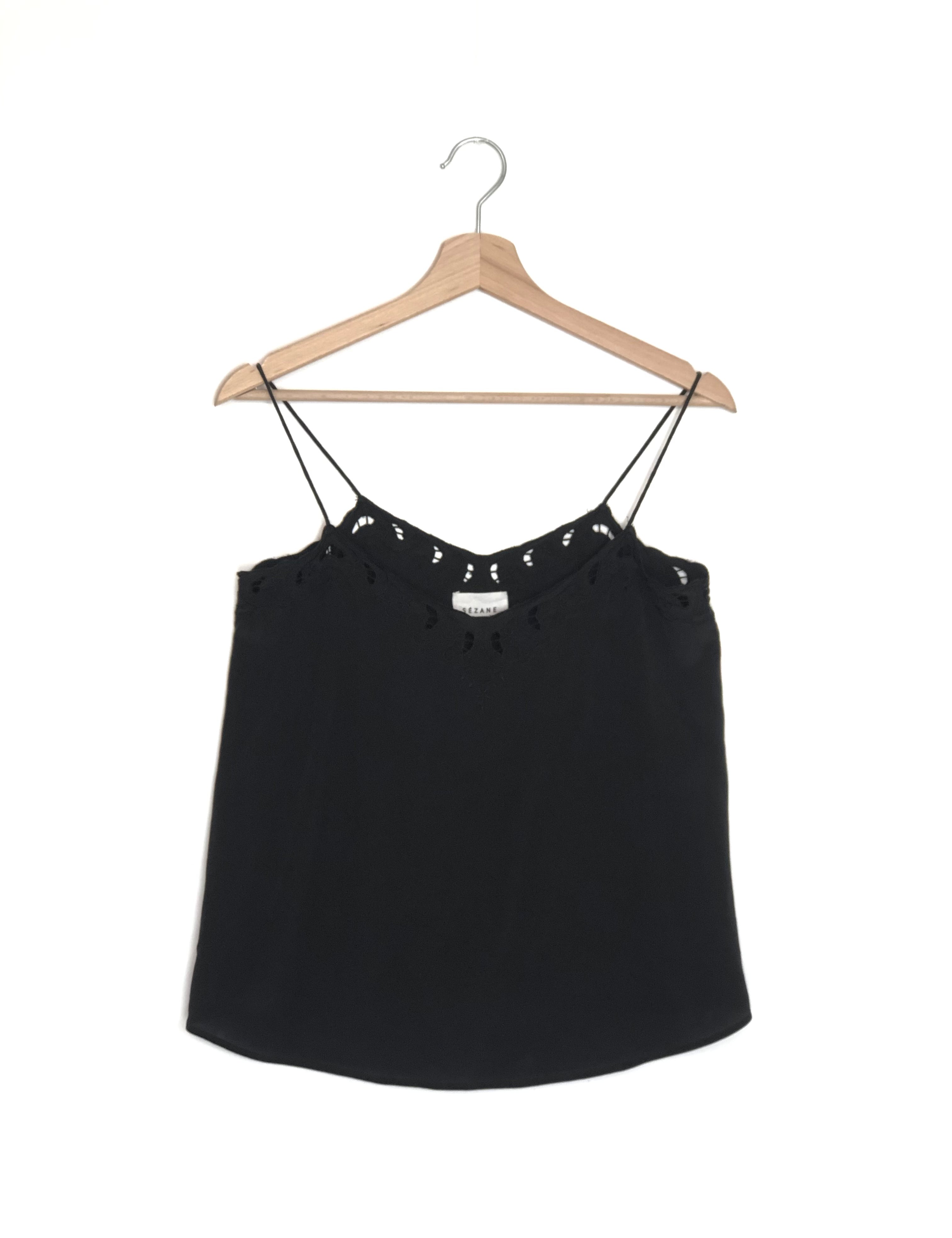 Black lace-trimmed top on a wooden hanger against a white background