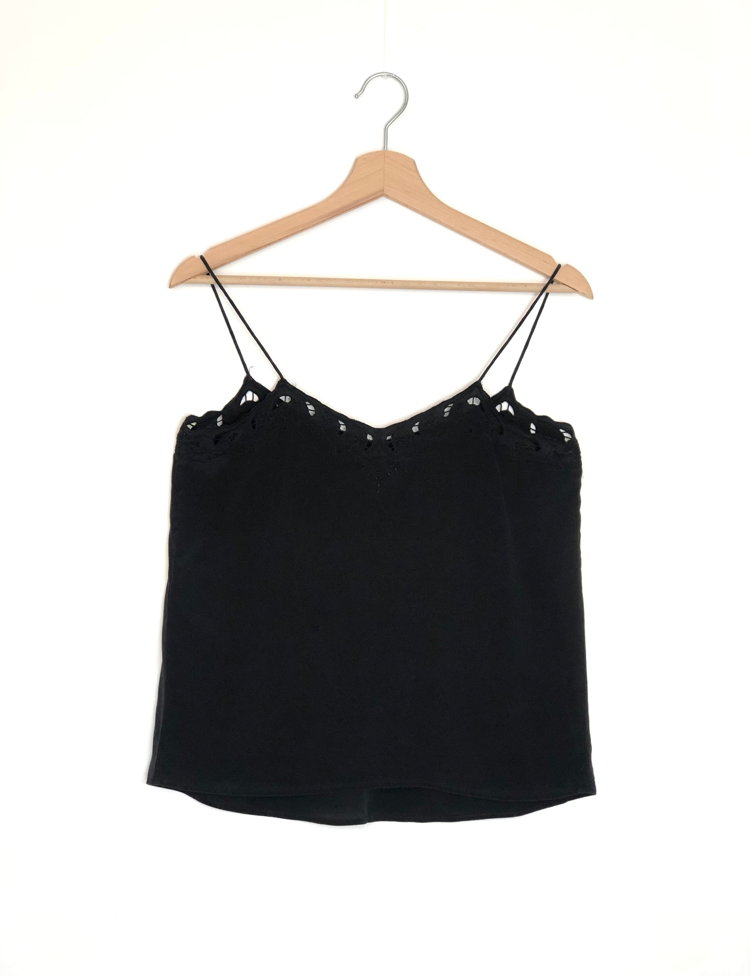 Black spaghetti strap top on a wooden hanger against a white background
