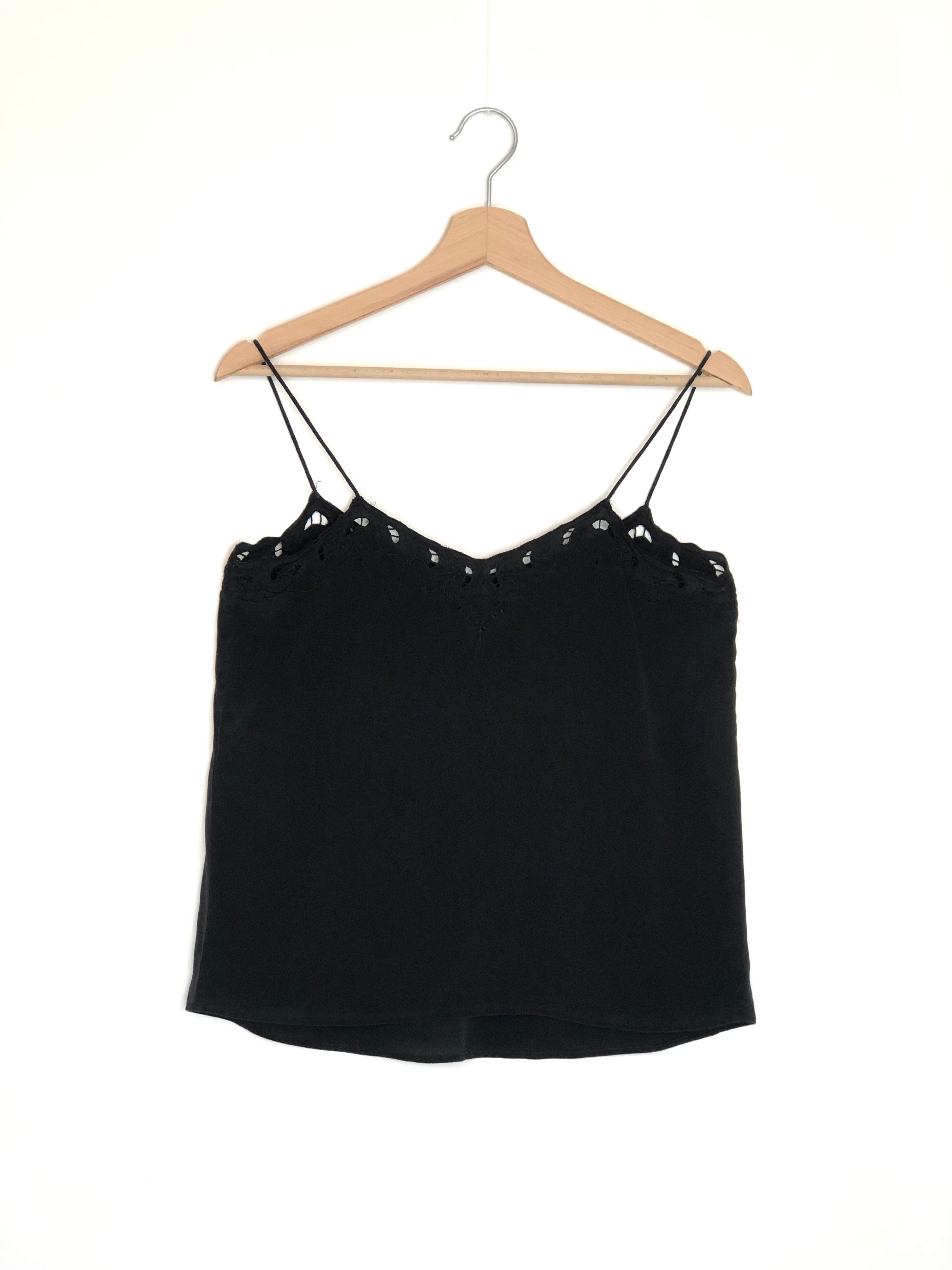 Black spaghetti strap top on a wooden hanger against a white background