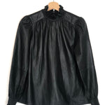 Black leather blouse with lace collar on a hanger against a white background