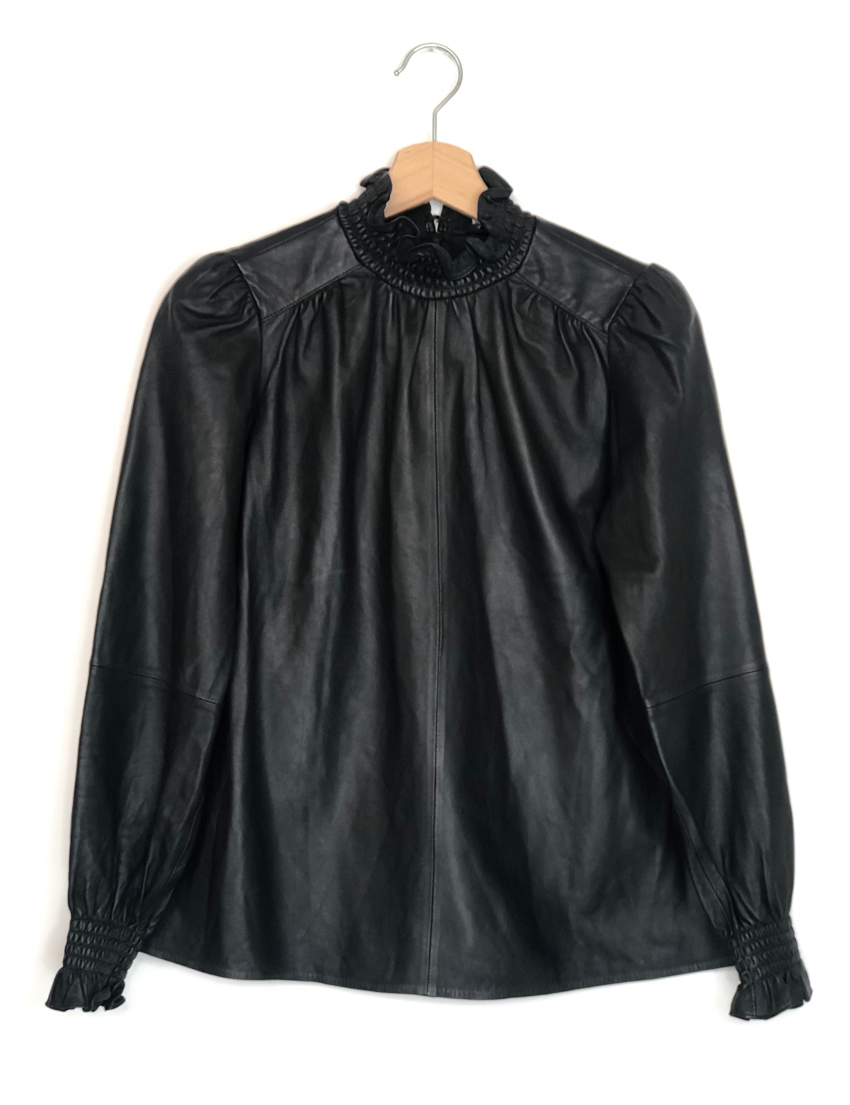 Black leather blouse with lace collar on a hanger against a white background