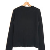 Black sweater on a hanger against a white background