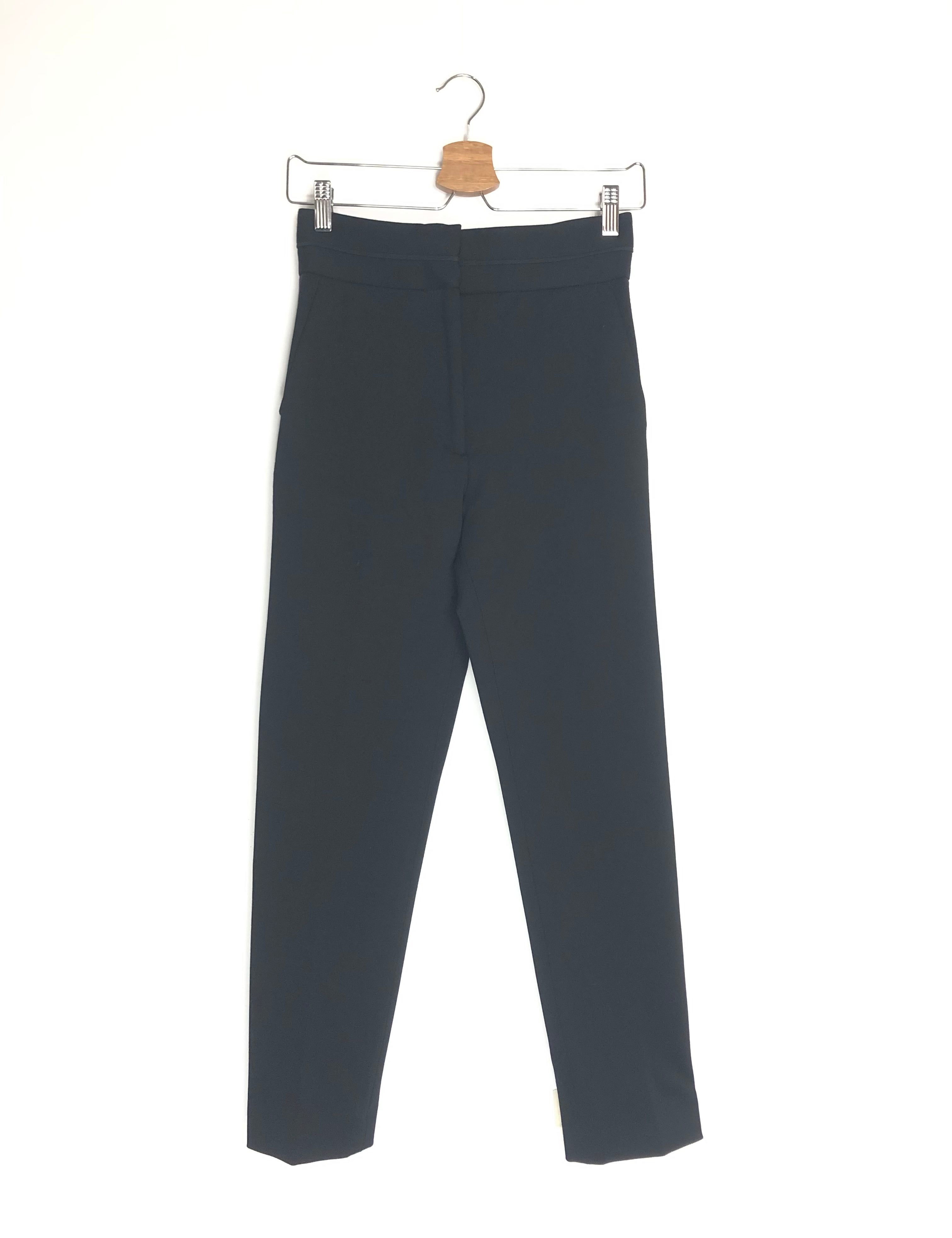 Black pants on a hanger against a white background
