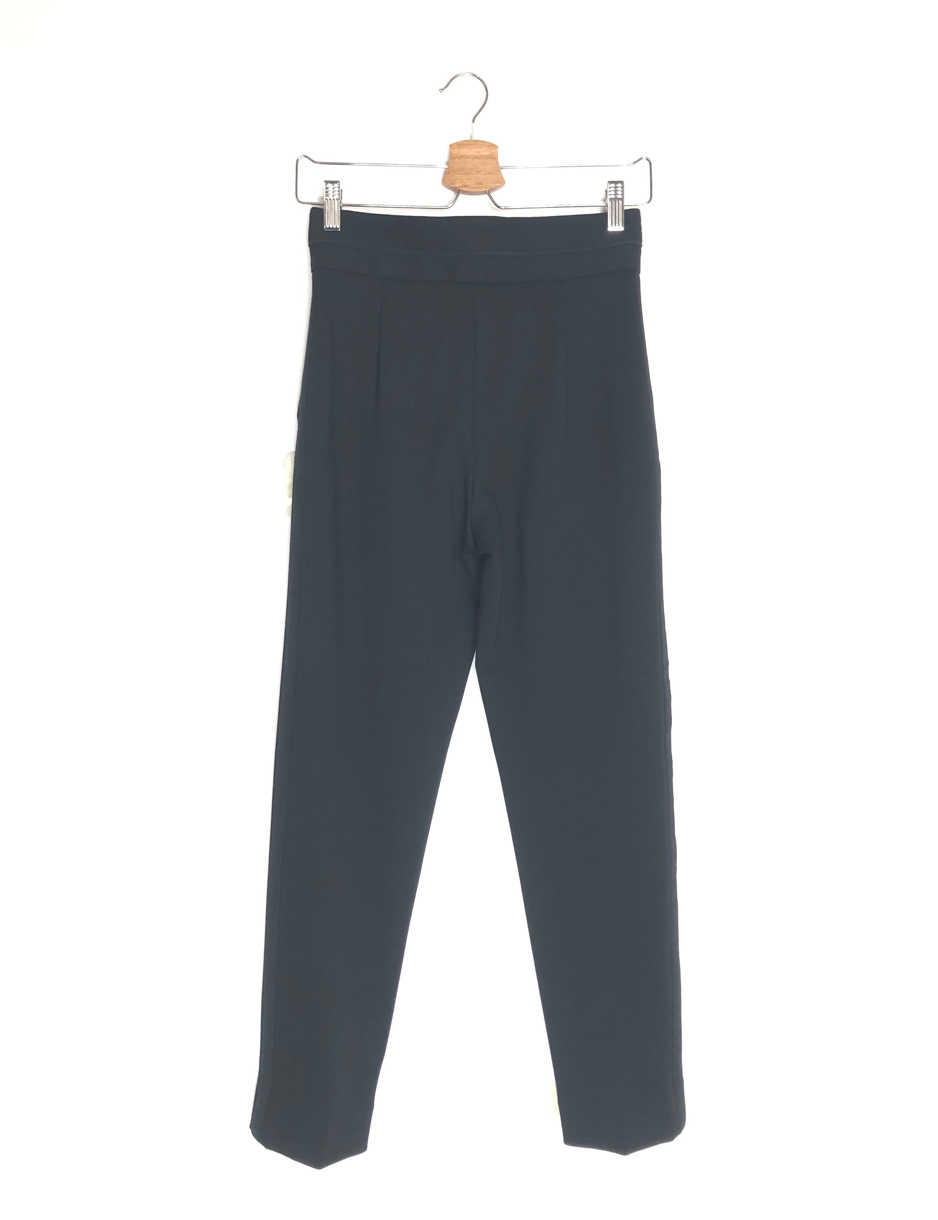 Black pants on a hanger against a white background
