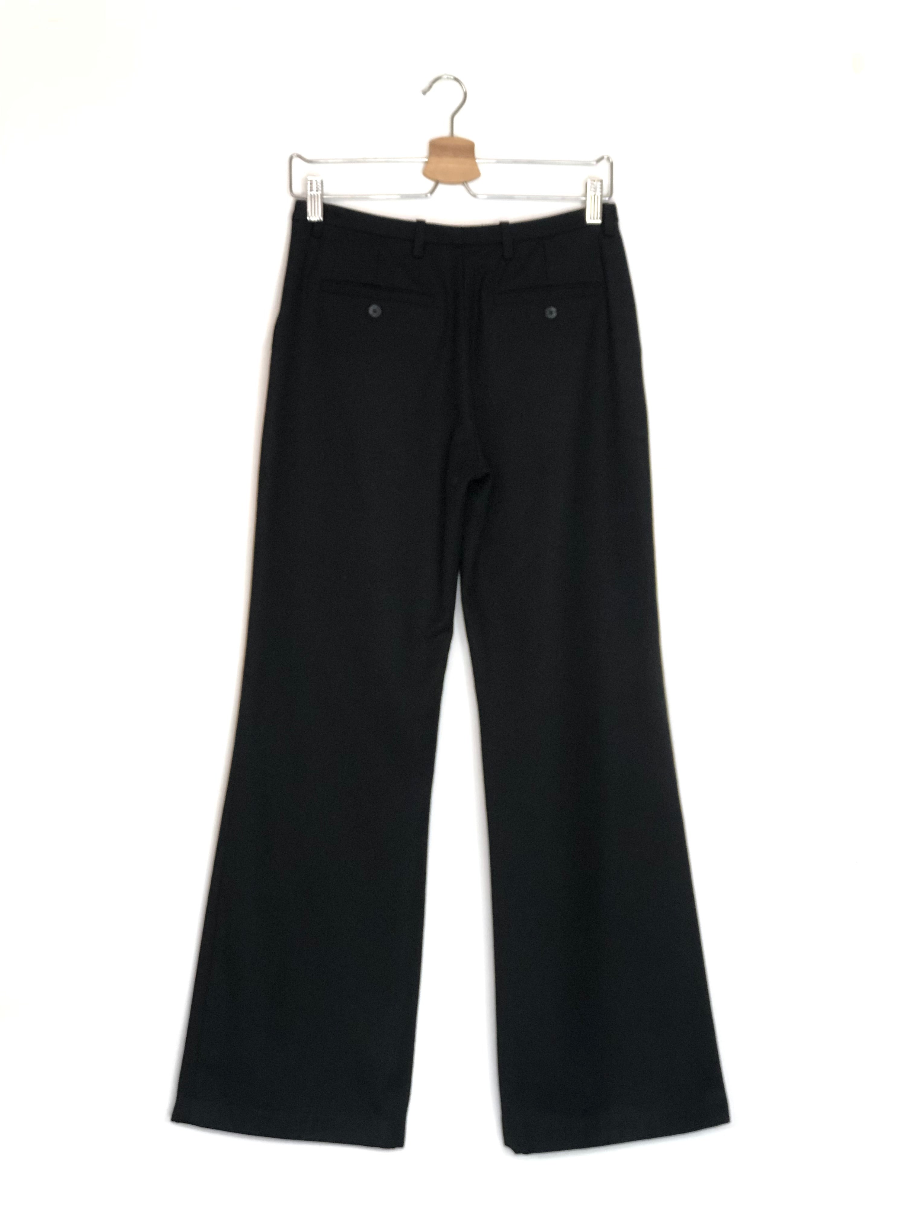 Black pants on a hanger against a white background