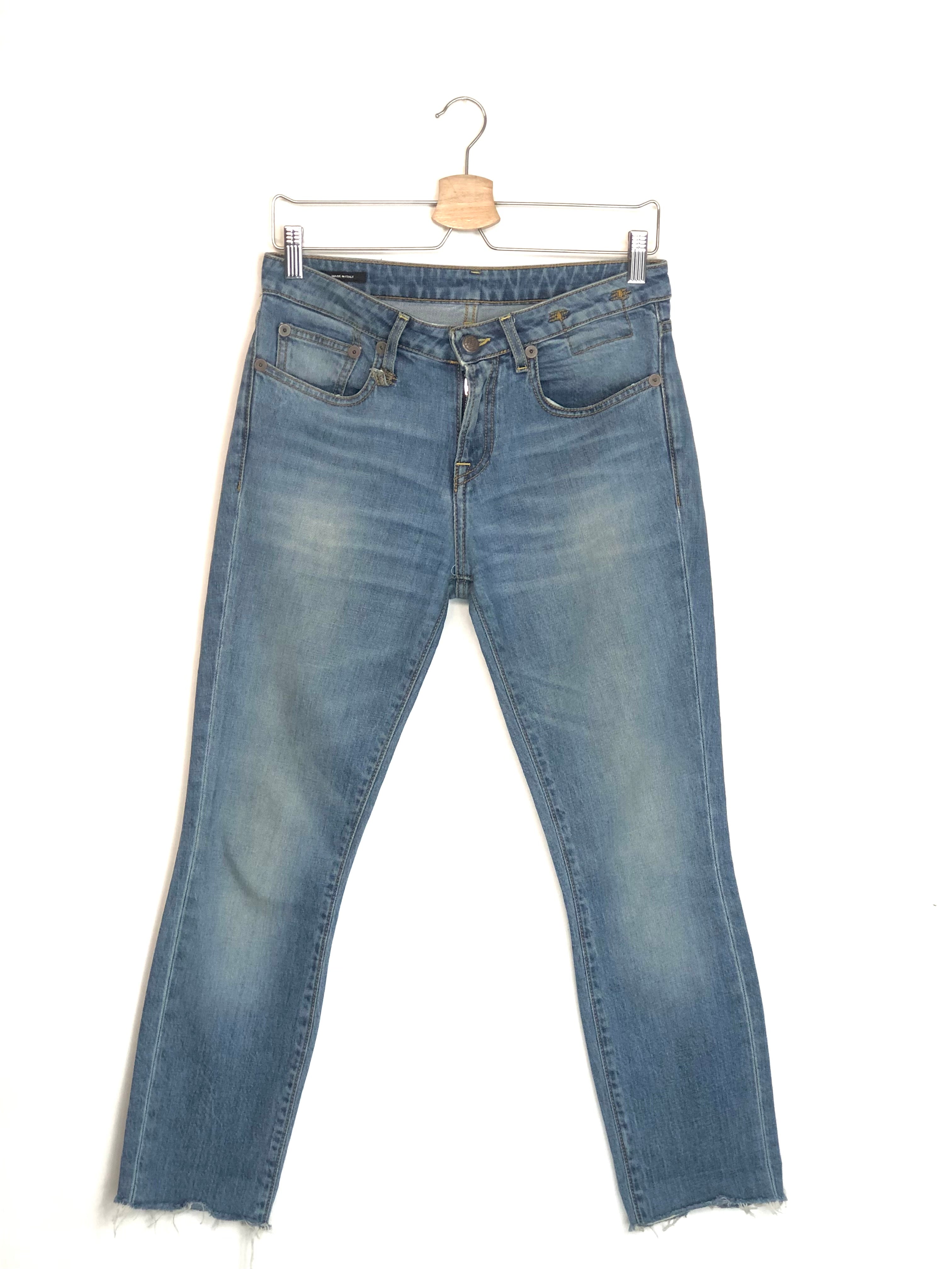 Blue jeans on a hanger against a white background