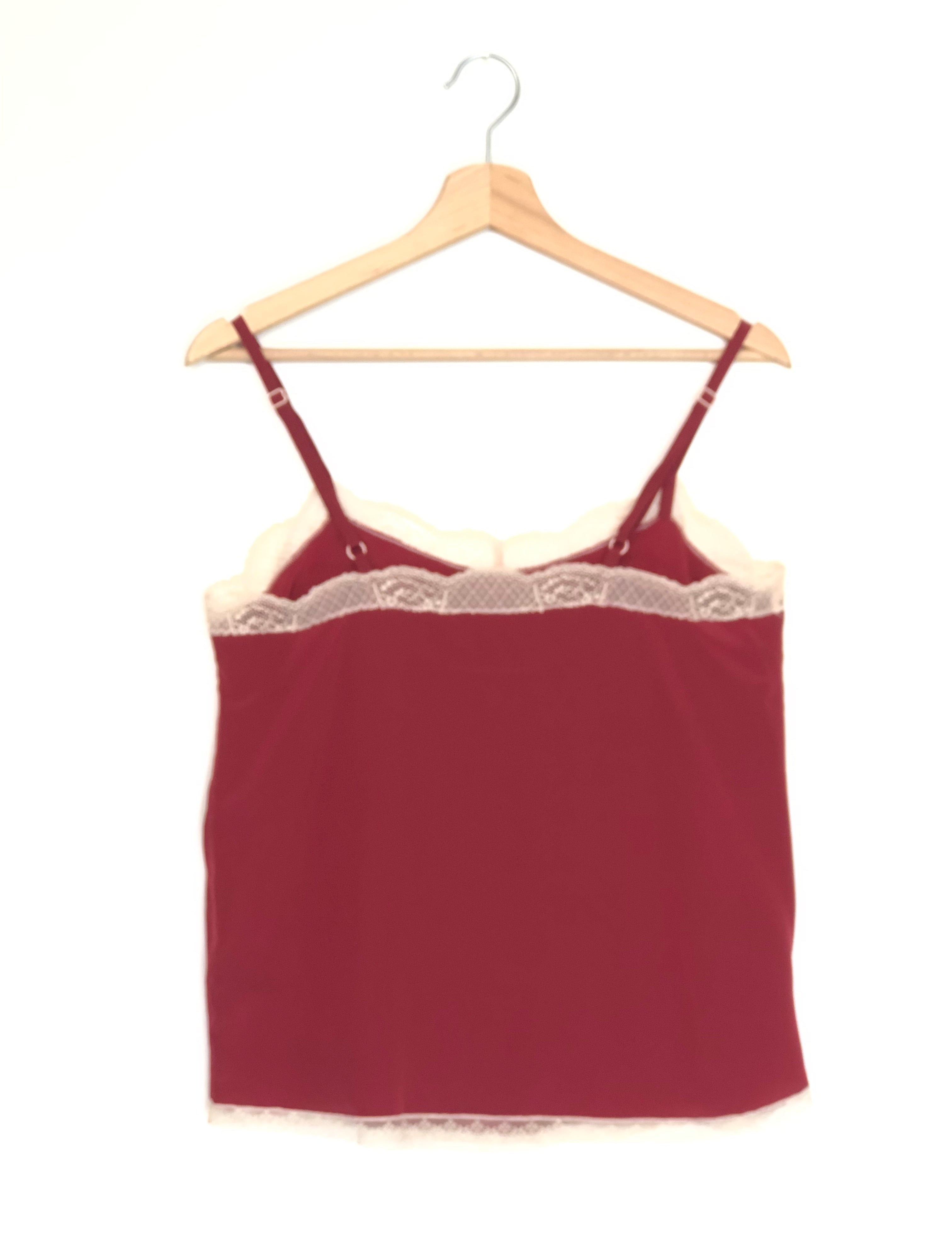 Red lace-trimmed camisole on a wooden hanger against a white background