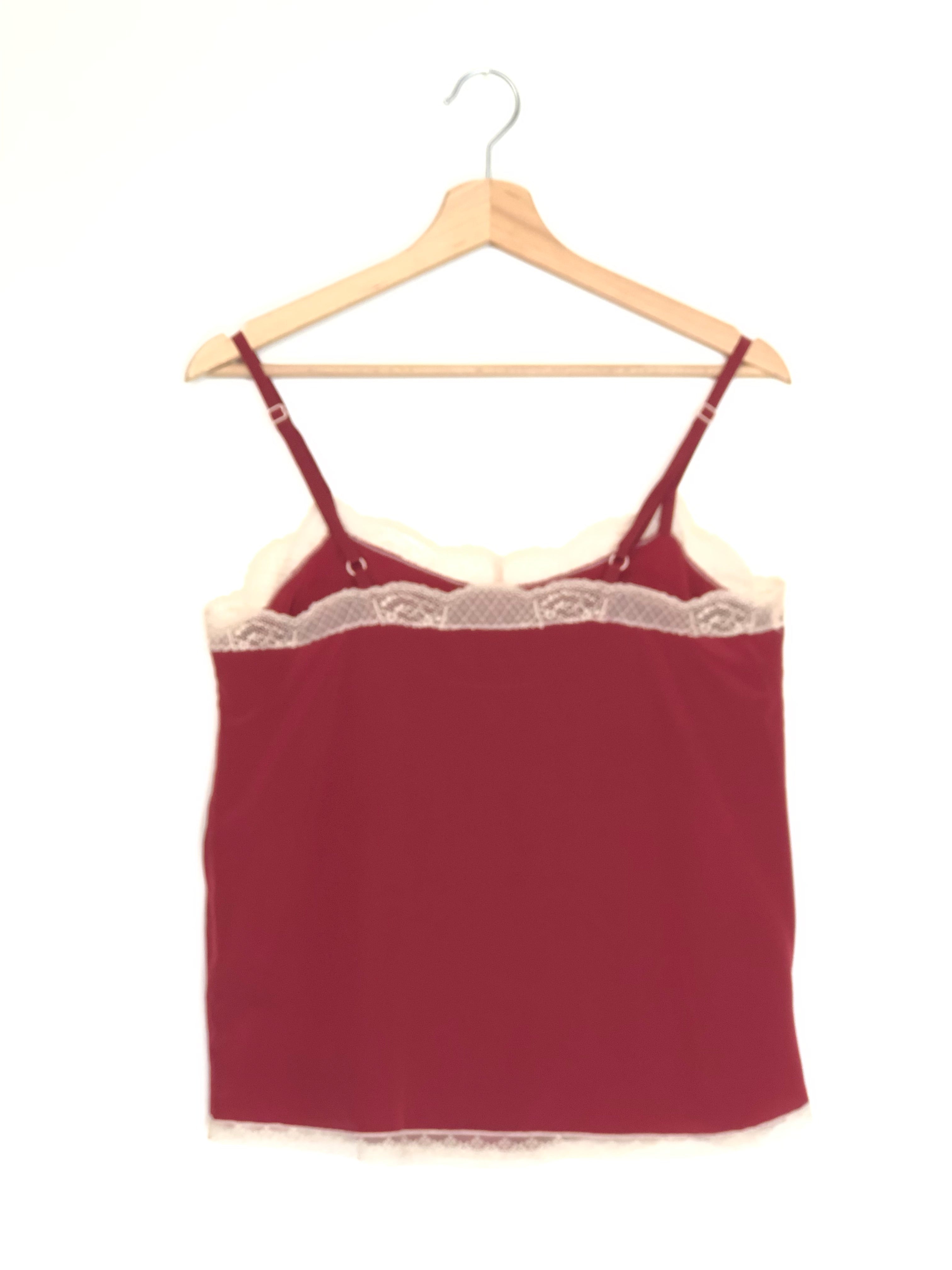 Red lace-trimmed camisole on a wooden hanger against a white background