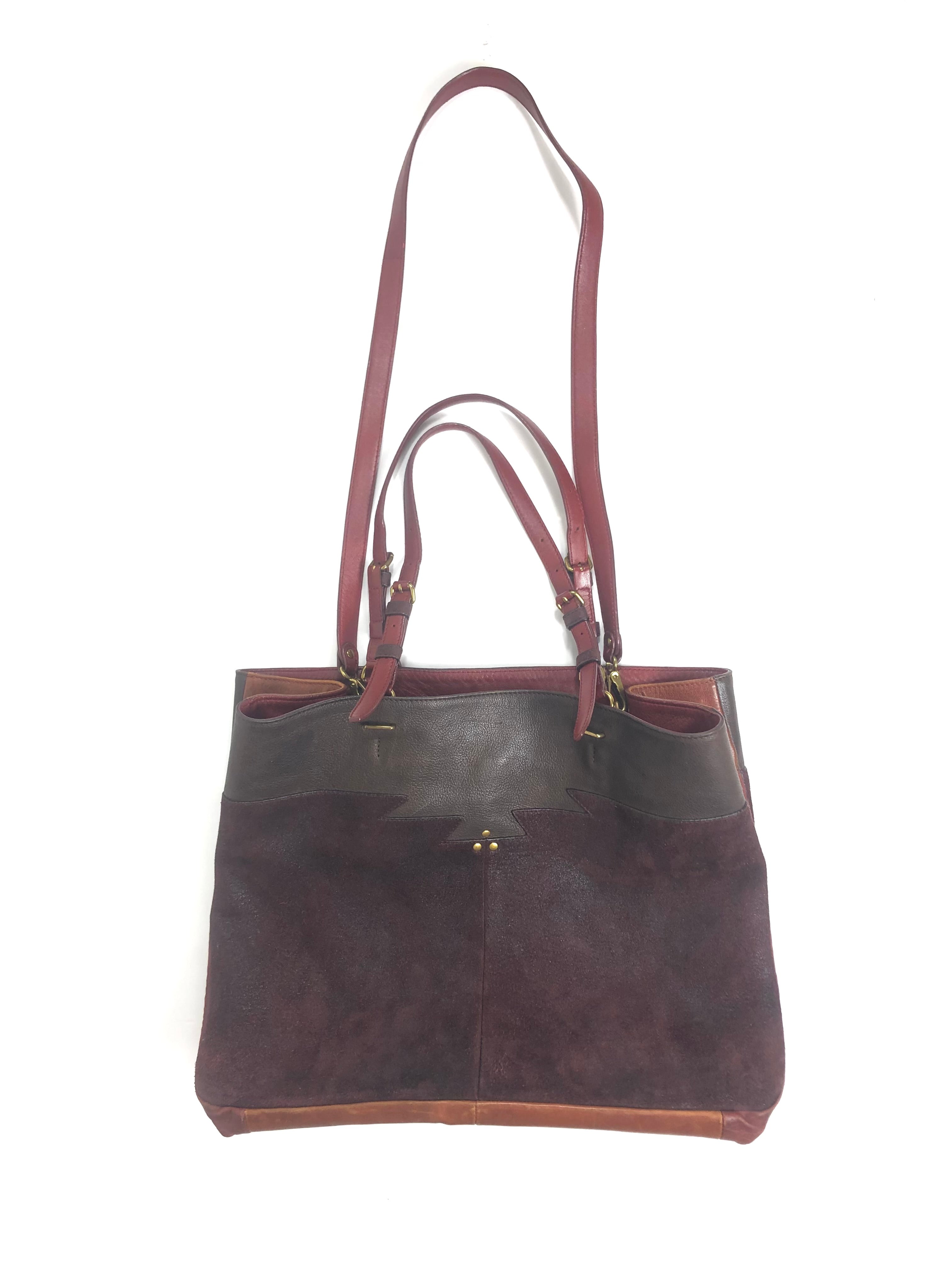 Brown leather handbag with gold clasp on a white background