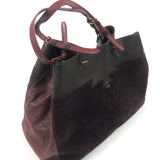 Brown leather handbag with a black section on a white background