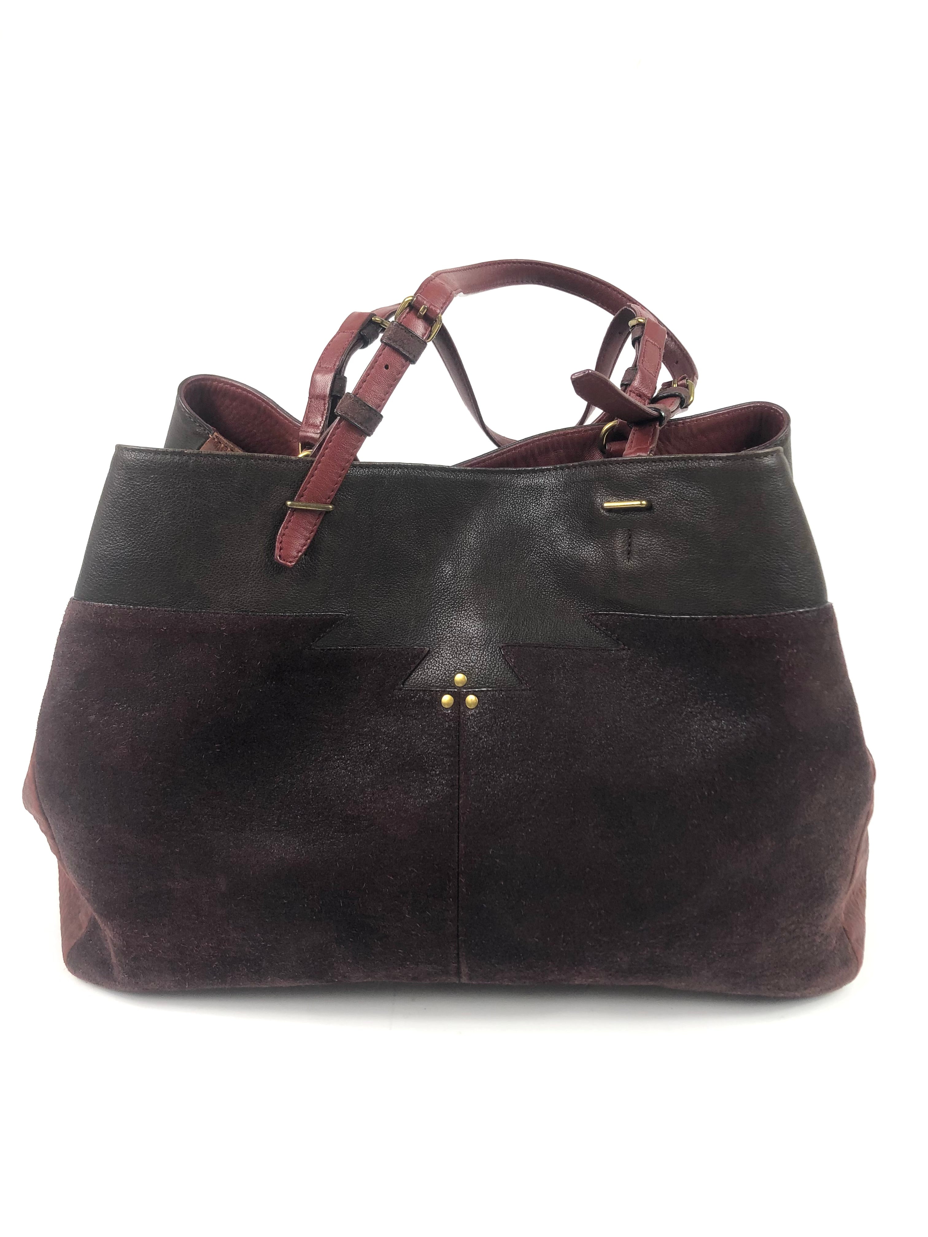 Brown leather handbag with gold accents on a white background