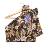 Floral halter top on a wooden hanger against a white background