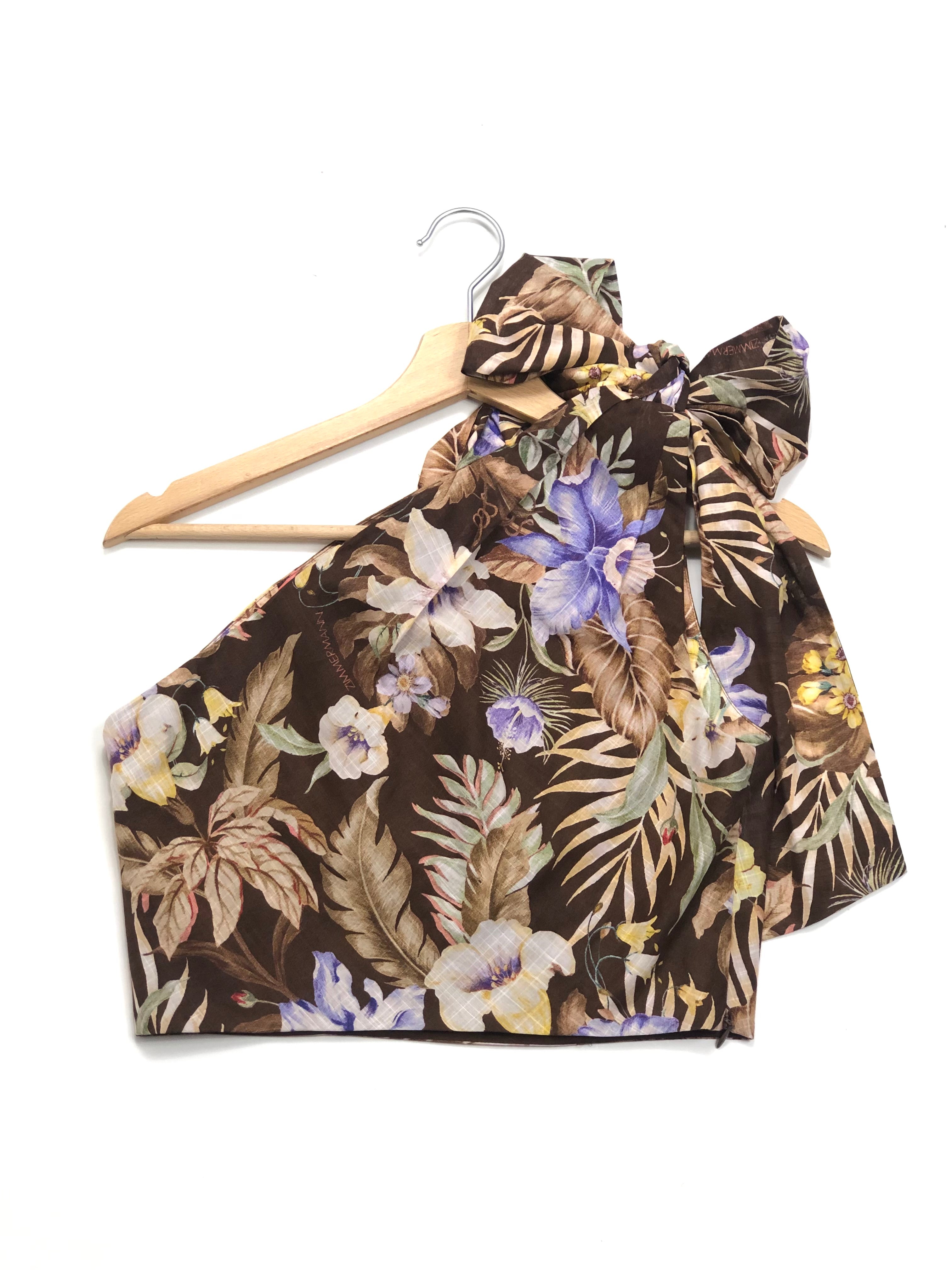 Floral halter top on a wooden hanger against a white background