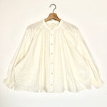 White blouse on a hanger against a white background