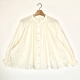 White blouse on a hanger against a white background