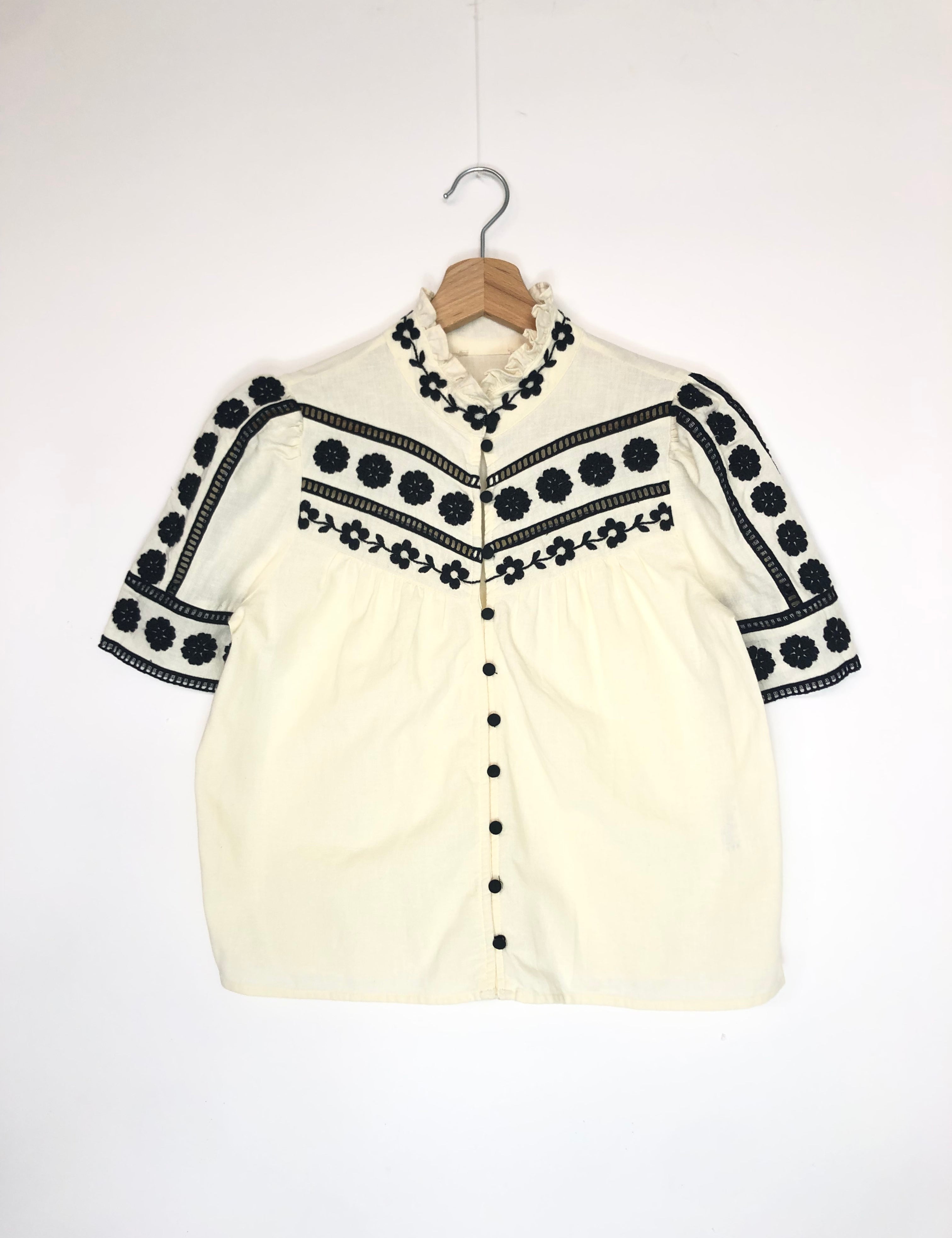 White shirt with black embroidery on a white background