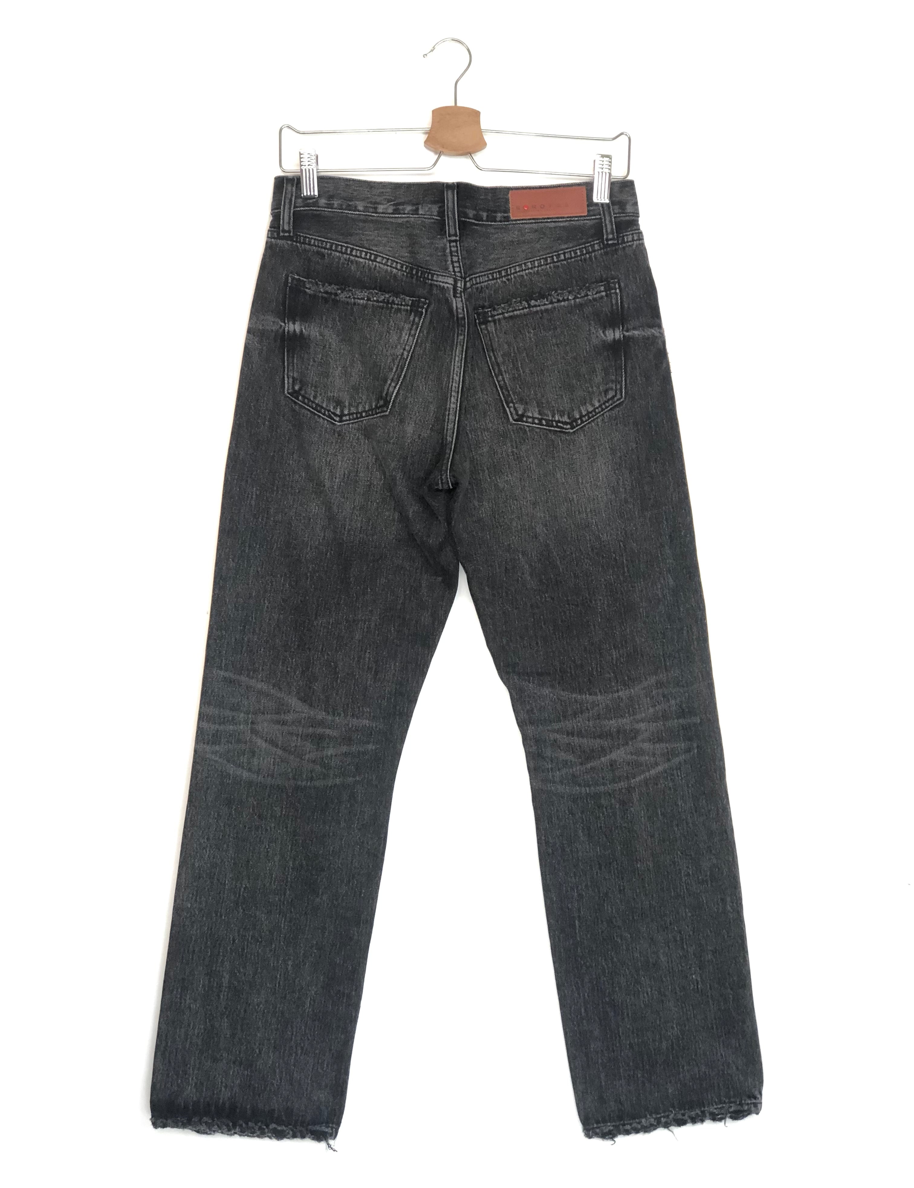 Black jeans on a hanger against a white background