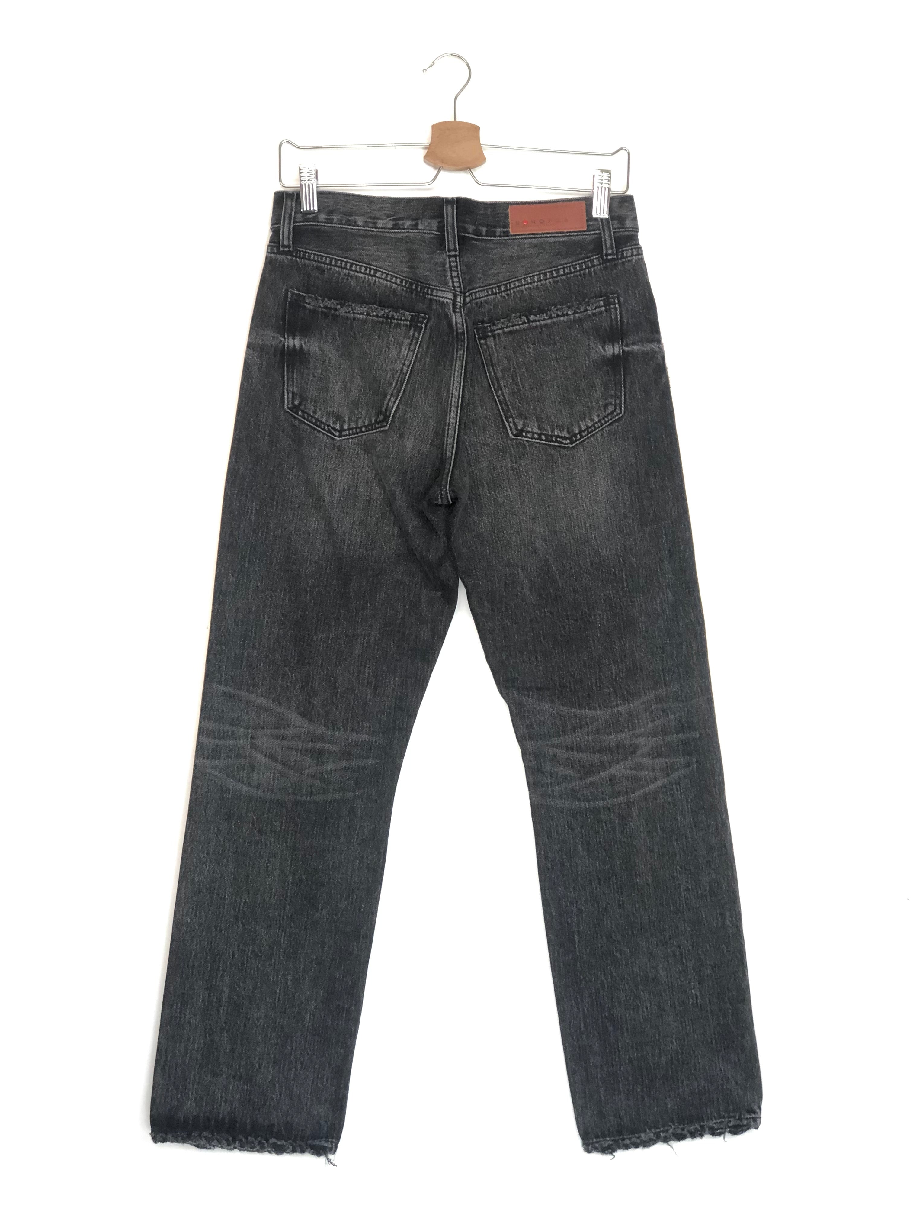 Black jeans on a hanger against a white background