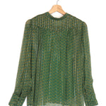 Green patterned blouse on a wooden hanger against a white background