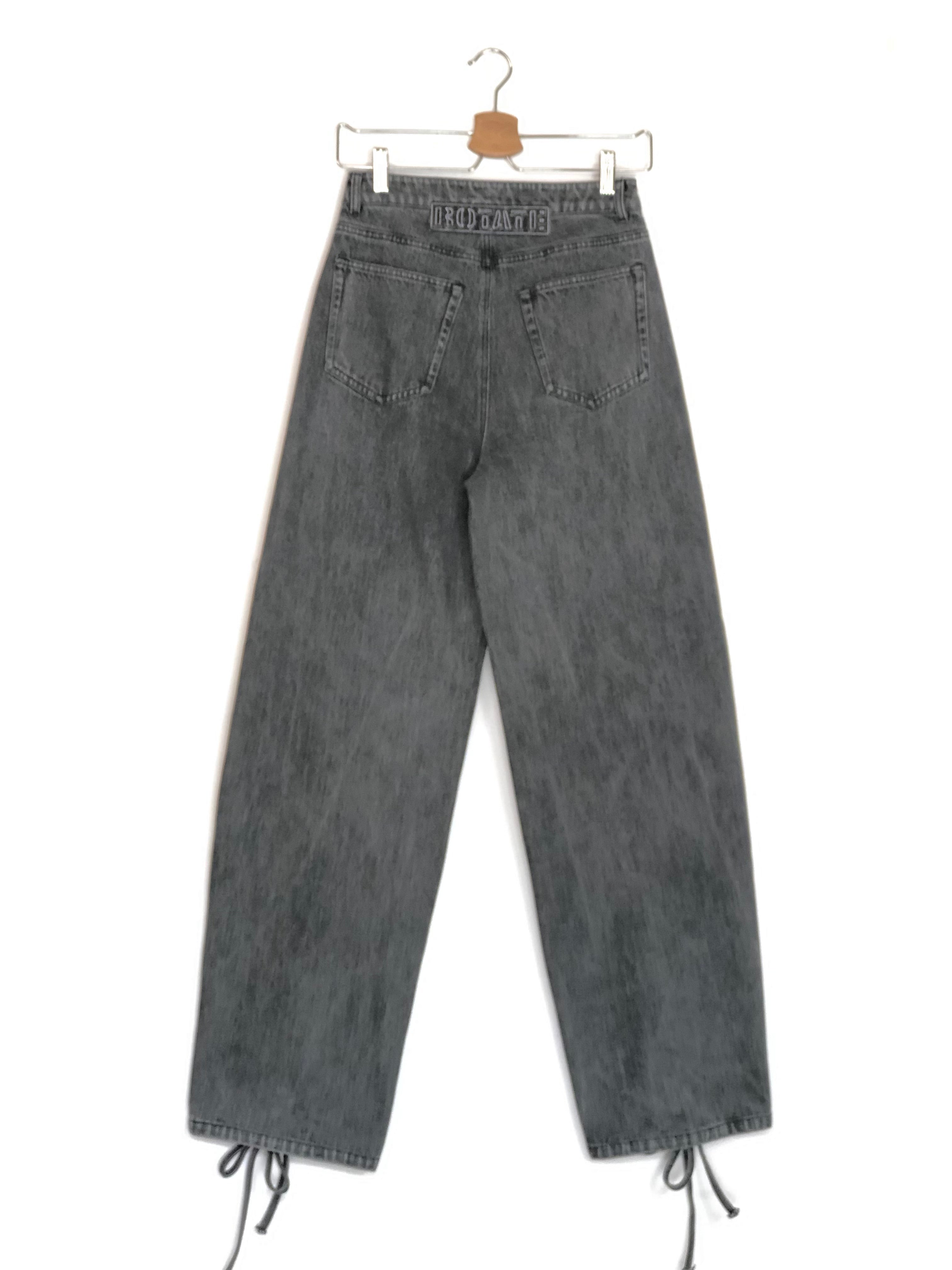Gray denim pants on a hanger against a white background