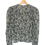 Black and white patterned blouse on a hanger against a white background
