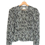 Black and white patterned blouse on a hanger against a white background