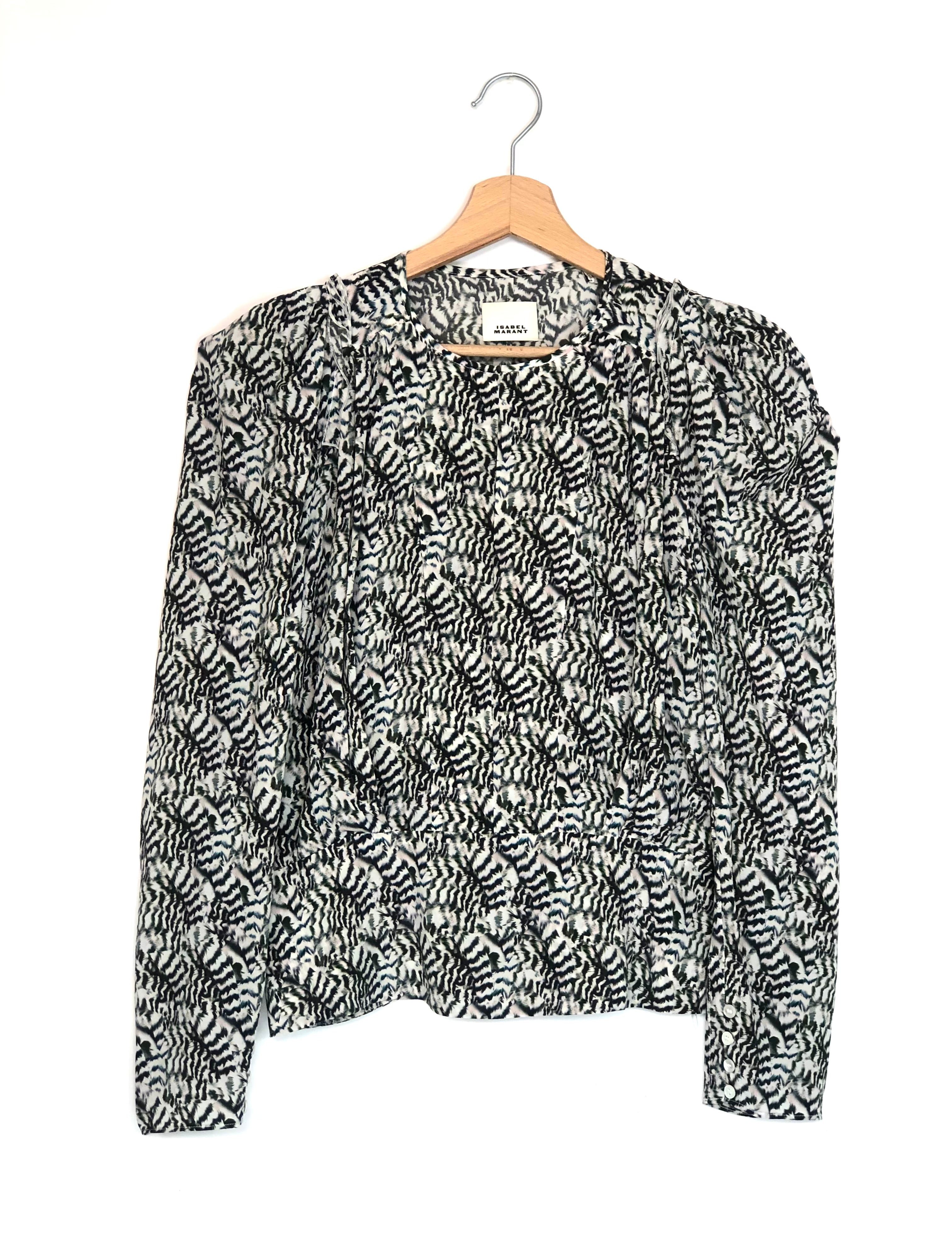 Black and white patterned blouse on a hanger against a white background