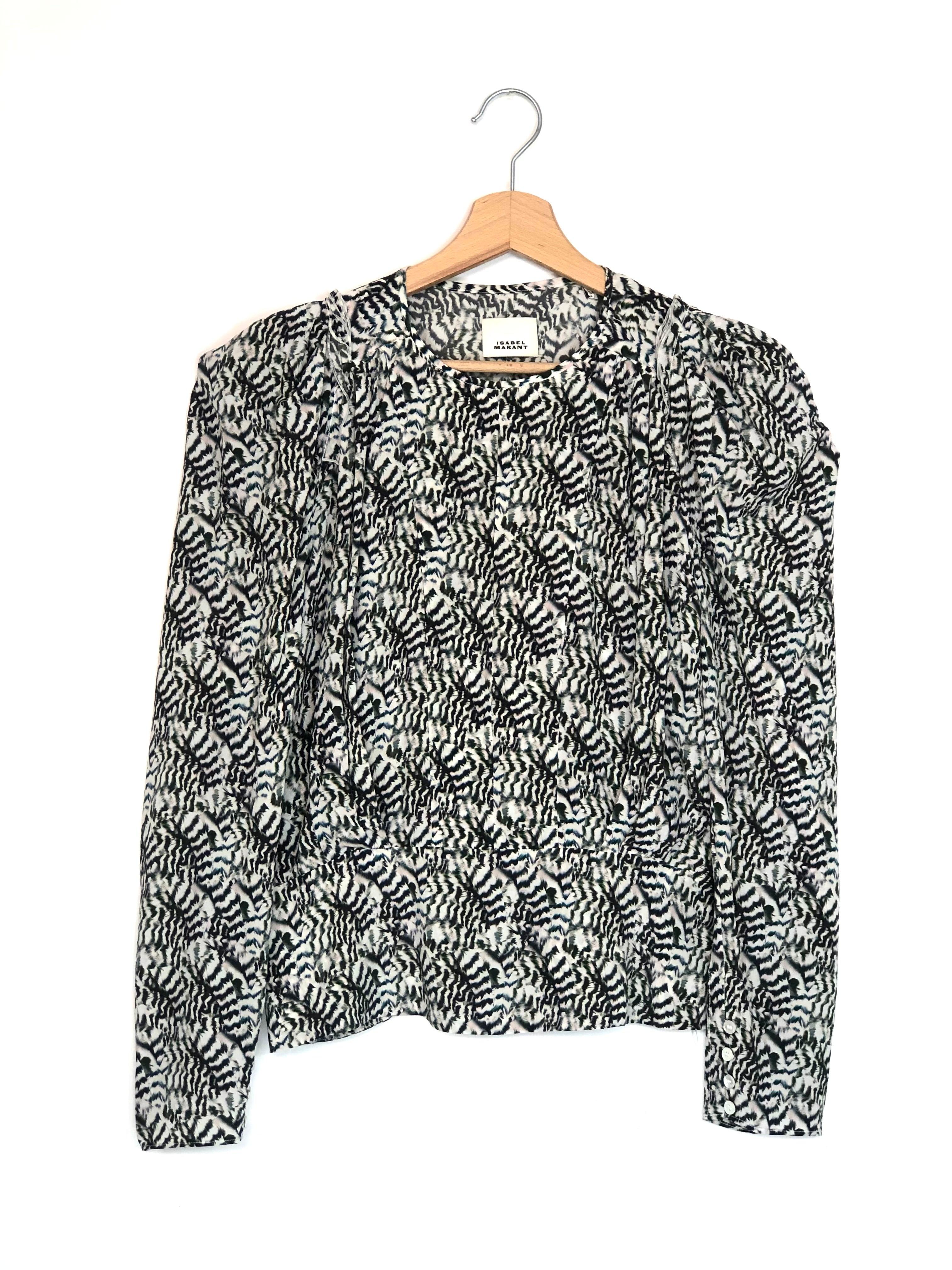Black and white patterned blouse on a hanger against a white background