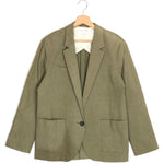 Green blazer on a hanger against a white background