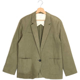 Green blazer on a hanger against a white background