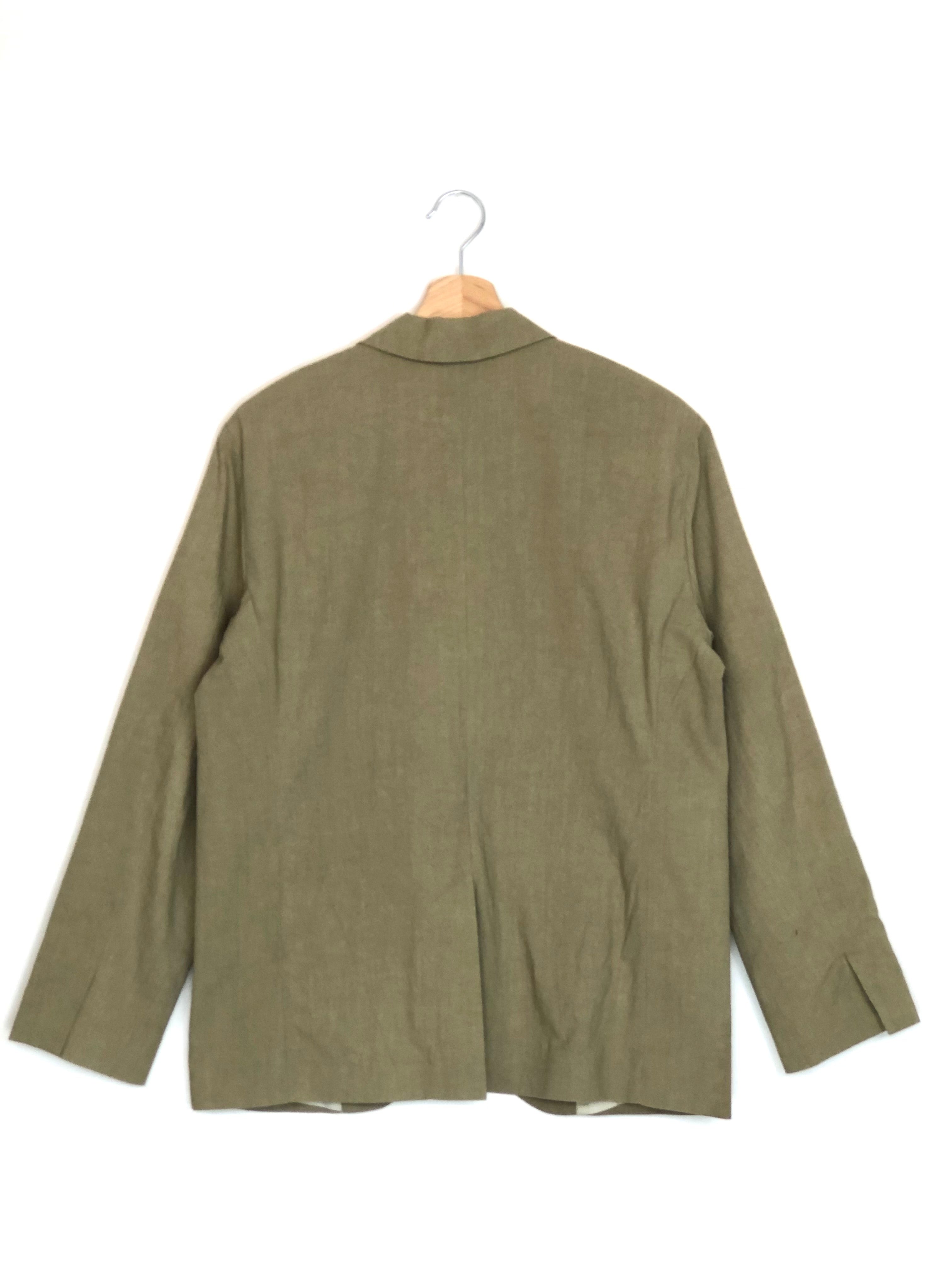 Green jacket on a hanger against a white background
