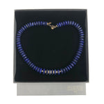 Blue beaded necklace on a black display card with a brand name, against a white background