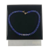 Blue beaded necklace on a black display card with a brand name, against a white background
