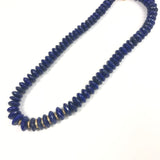 Blue beaded necklace on a white background