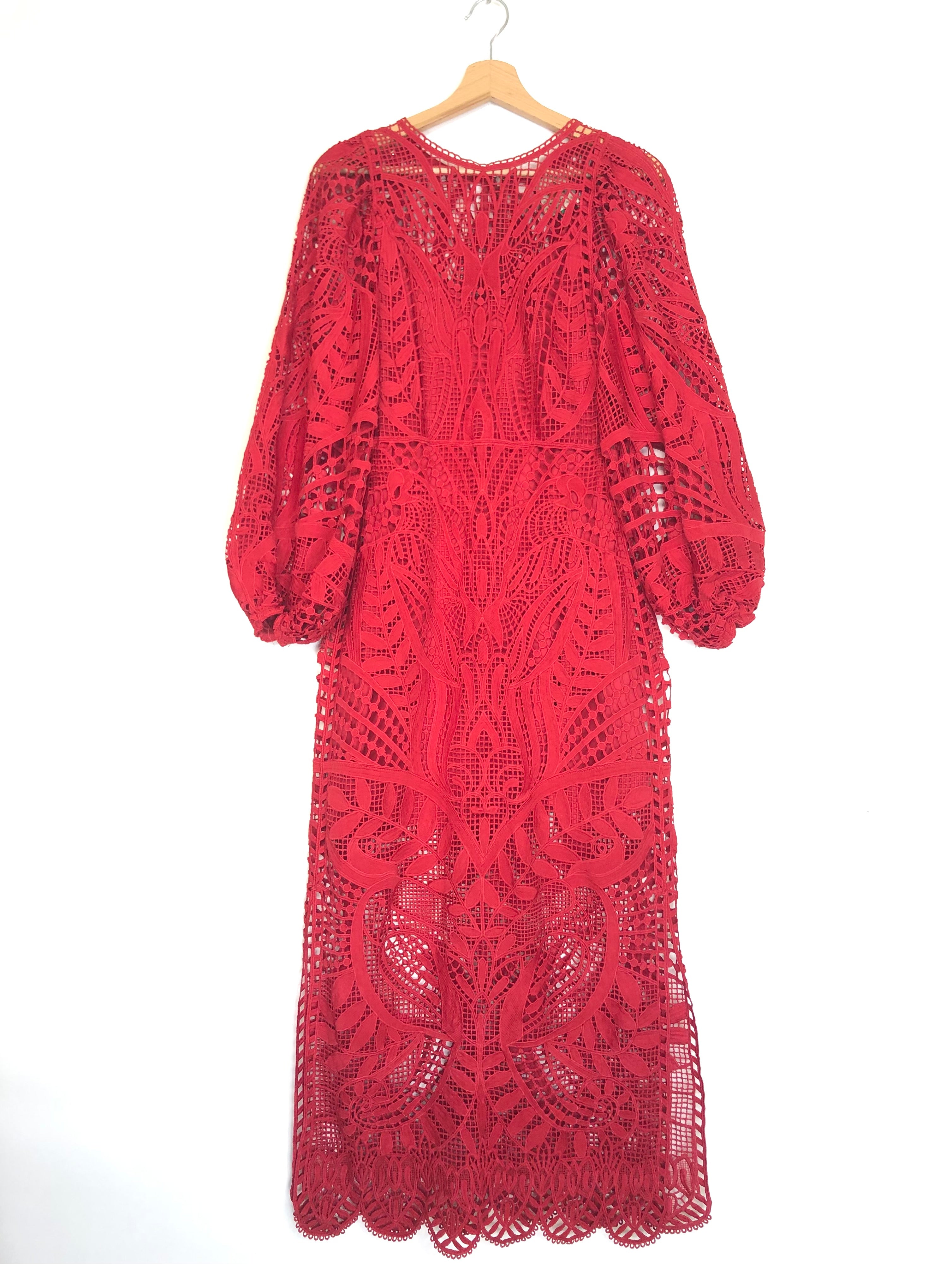Red lace dress on a hanger against a white background