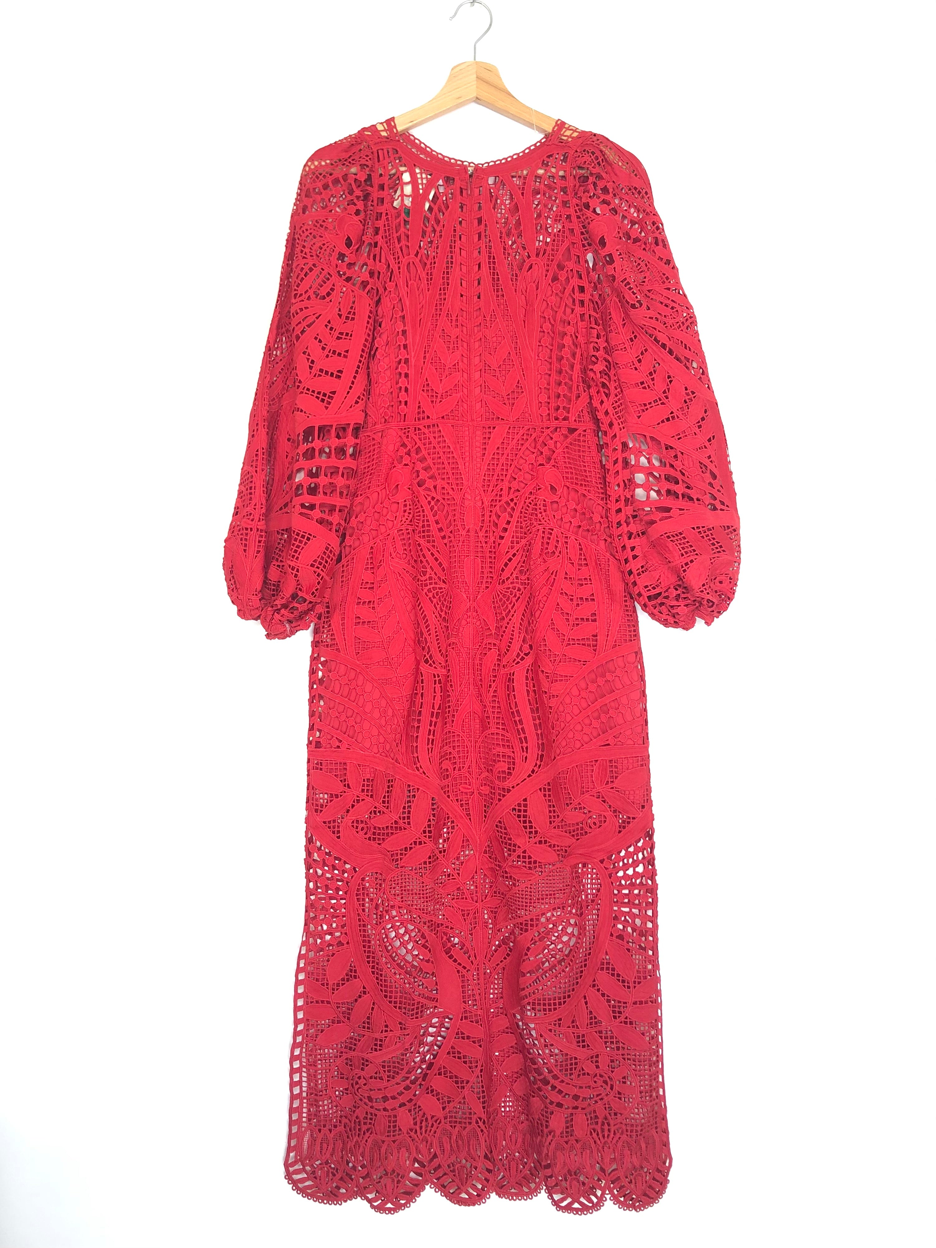 Red lace dress on a hanger against a white background