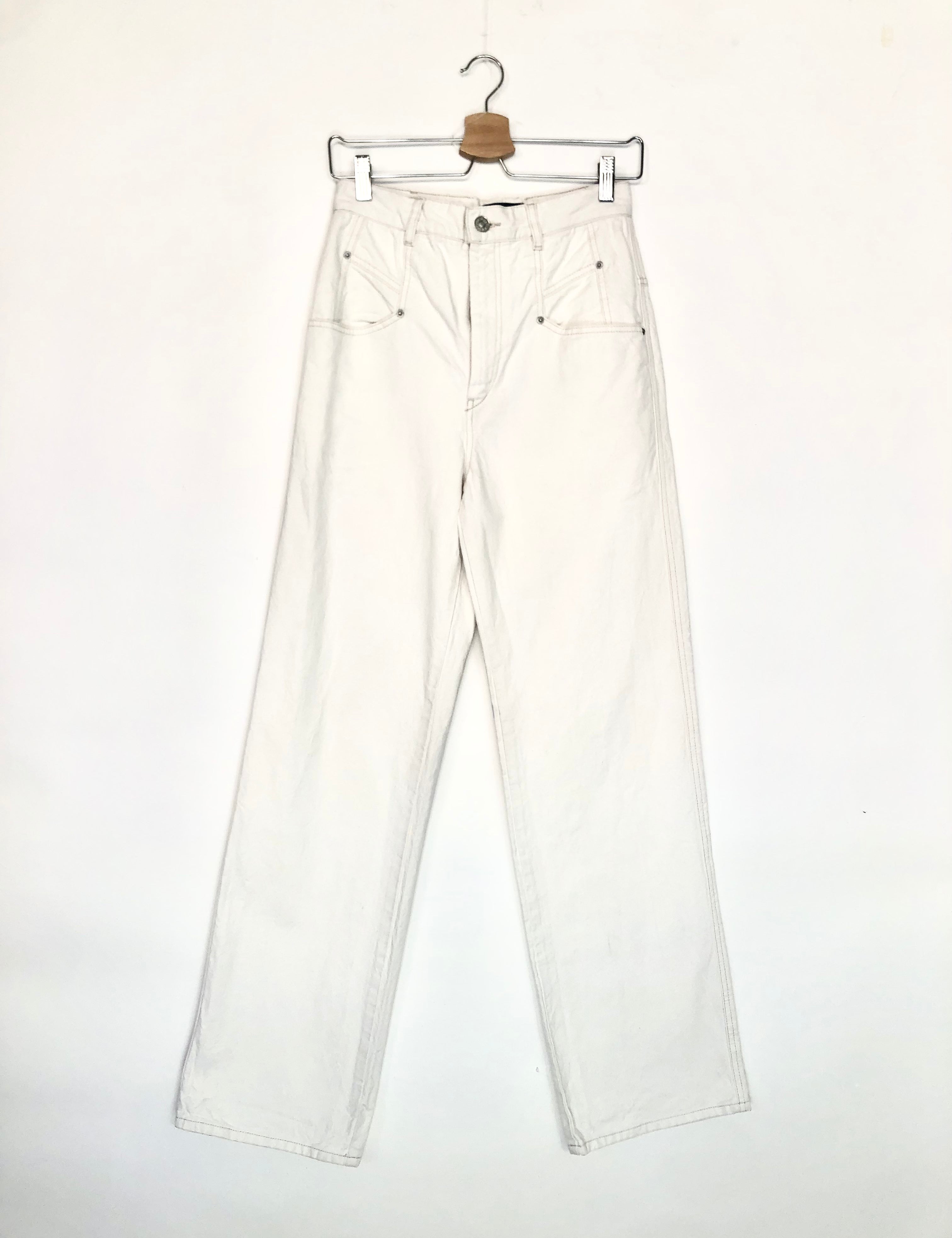 White jeans on a hanger against a white background