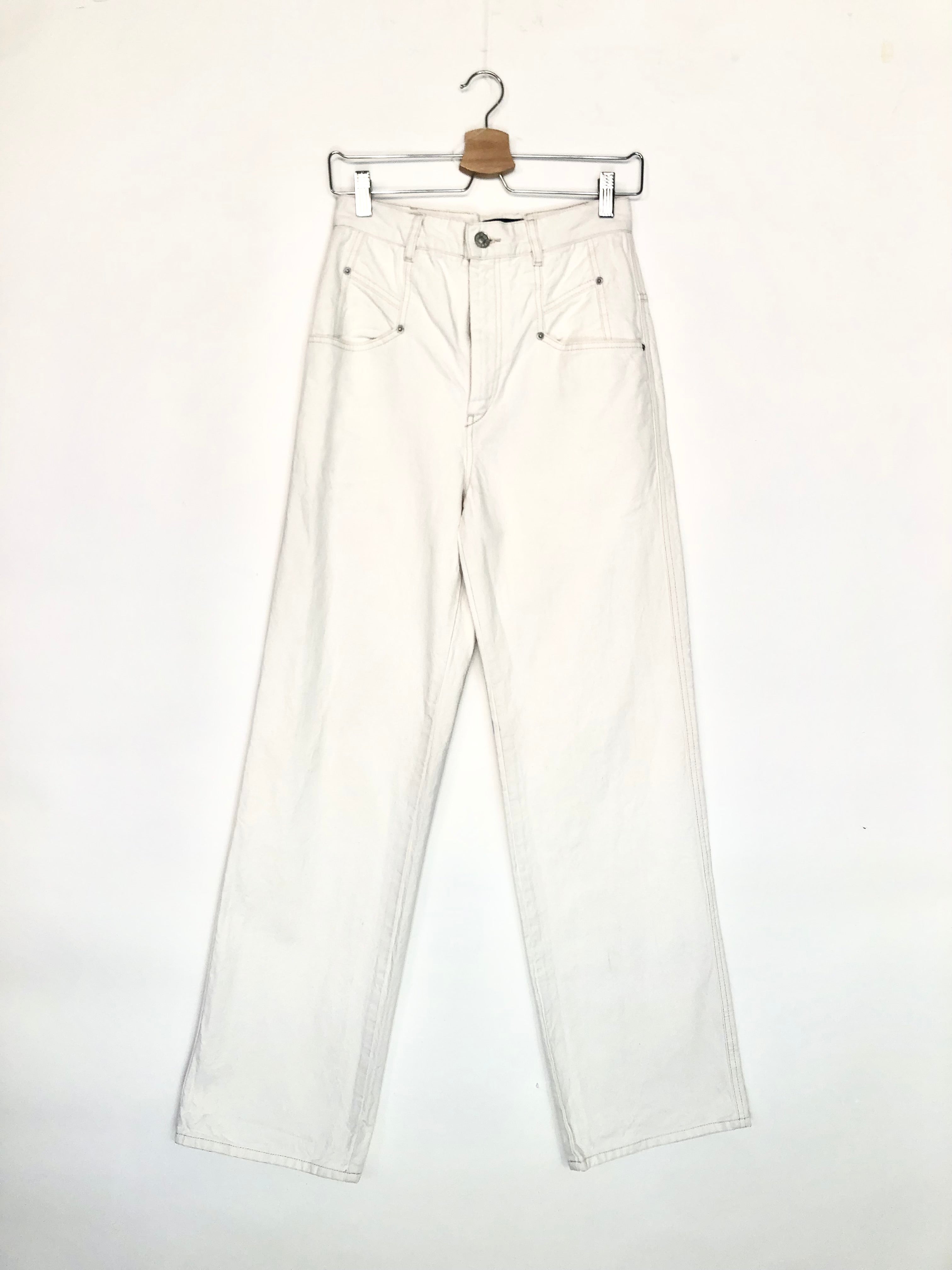 White jeans on a hanger against a white background