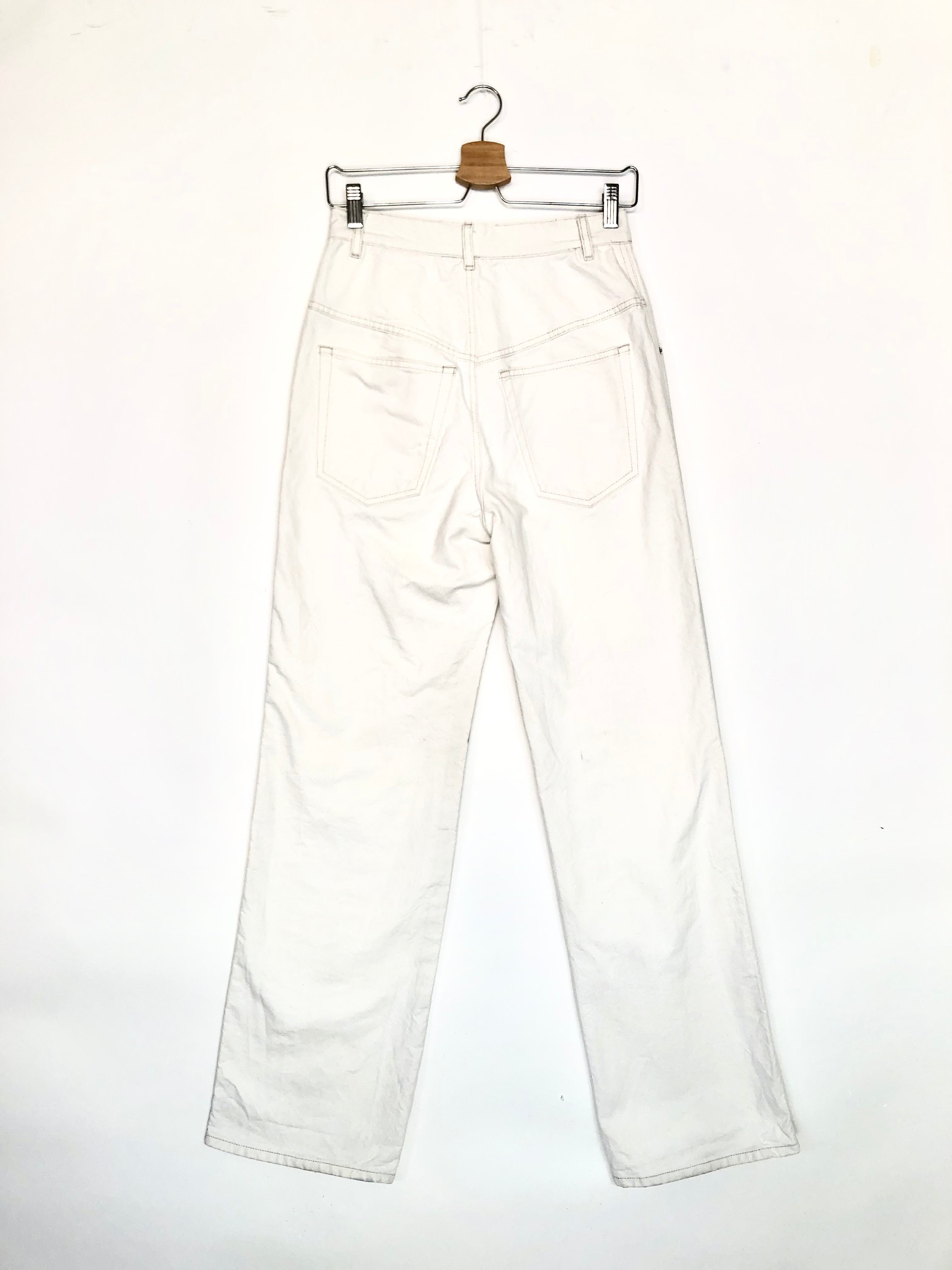 White pants on a hanger against a white background