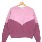 Two-tone pink and purple sweatshirt on a hanger against a white background