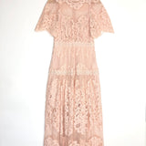 Pink lace dress on a hanger against a white background