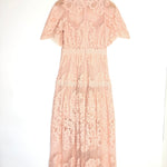 Pink lace dress on a hanger against a white background