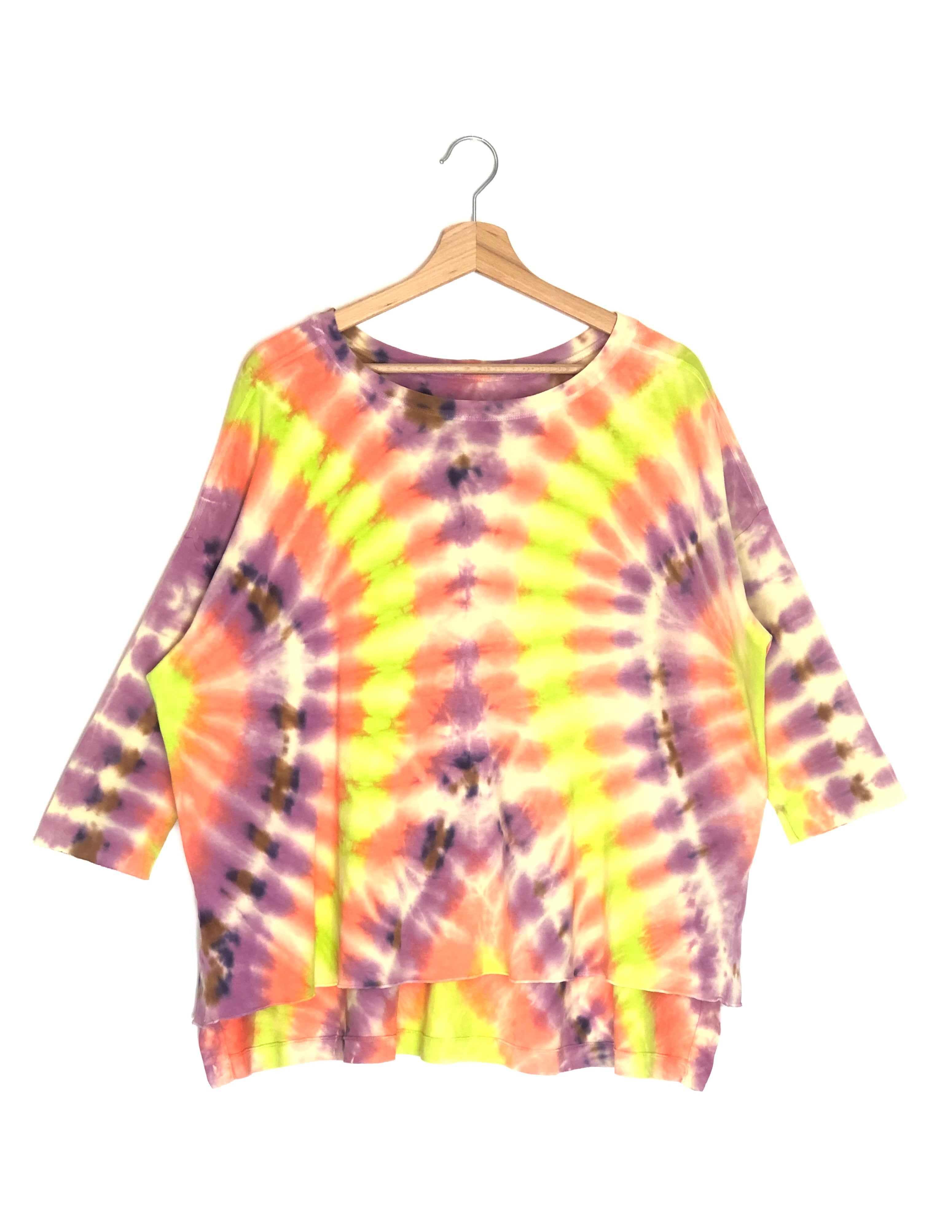 Tie-dye shirt on a hanger against a white background