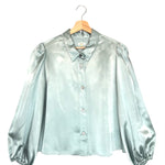 Rain-blue blouse on a hanger against a white background