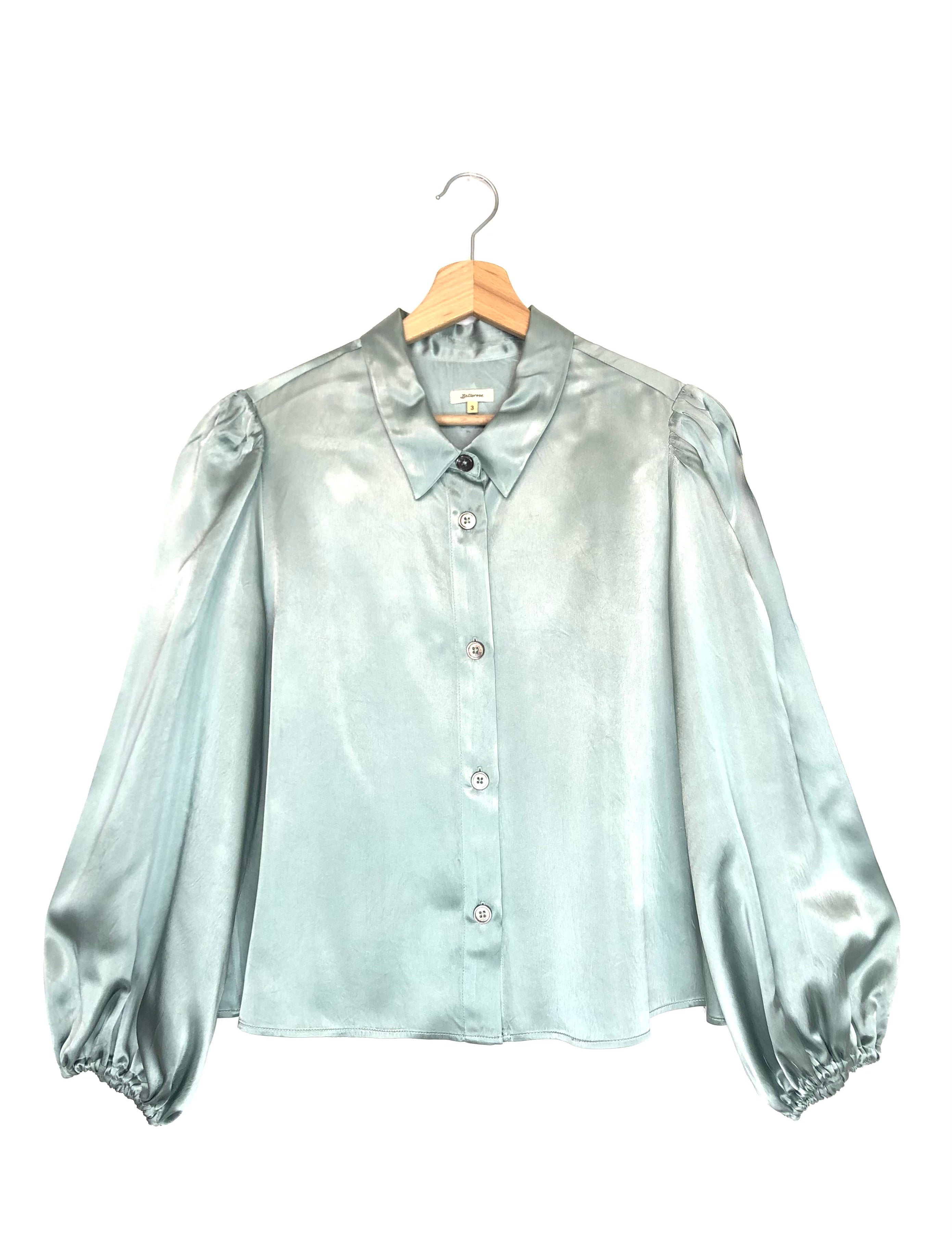 Rain-blue blouse on a hanger against a white background